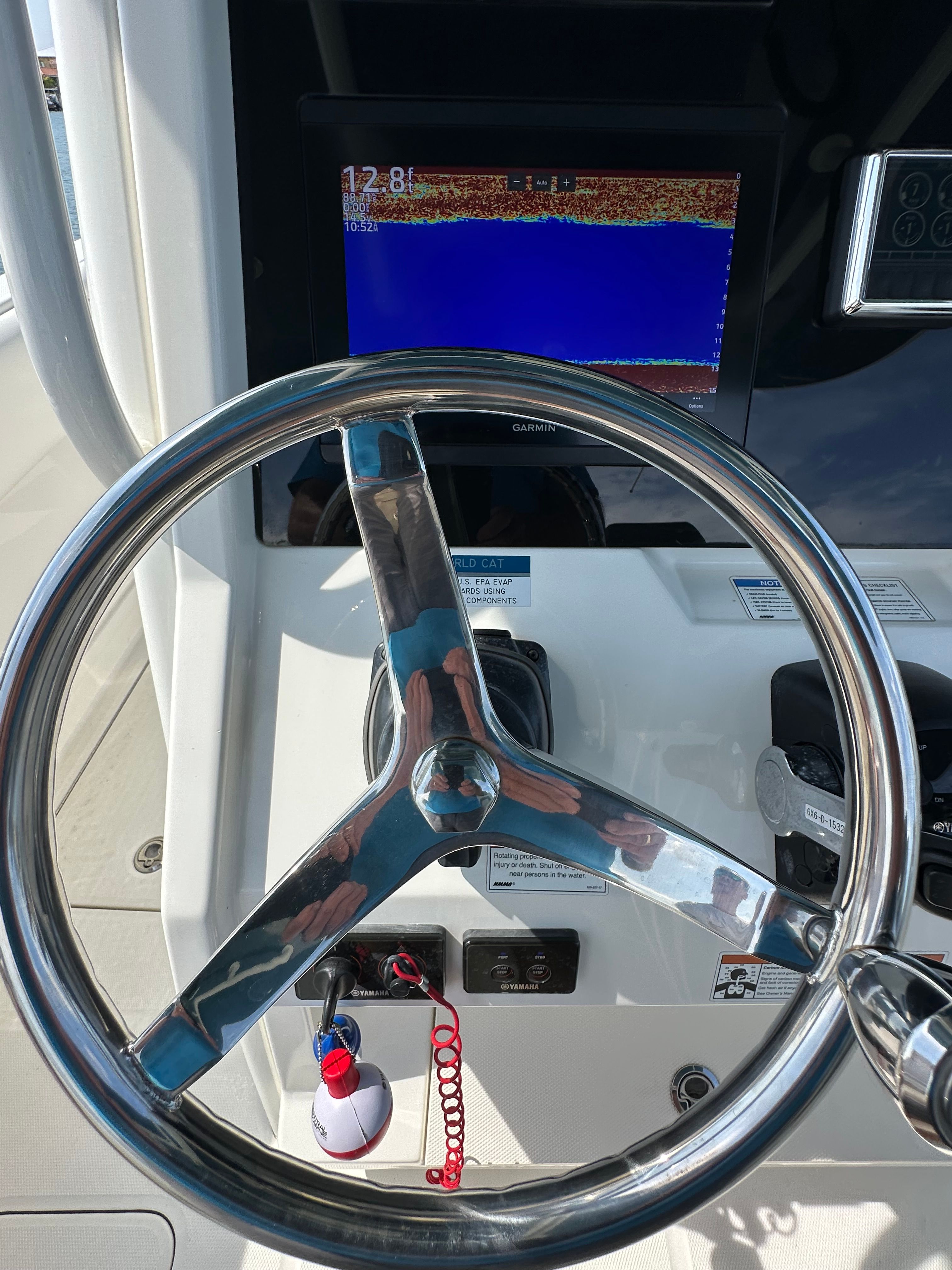 The image shows the helm of a World Cat 280 CC-X boat with a display screen.