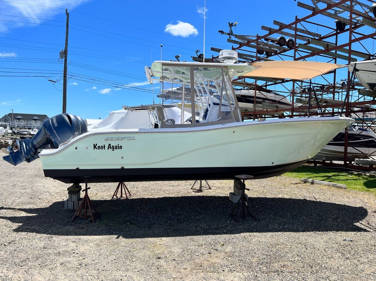 A 2017 Sea Fox Commander 266 is on a dry dock. The sky is clear and blue.