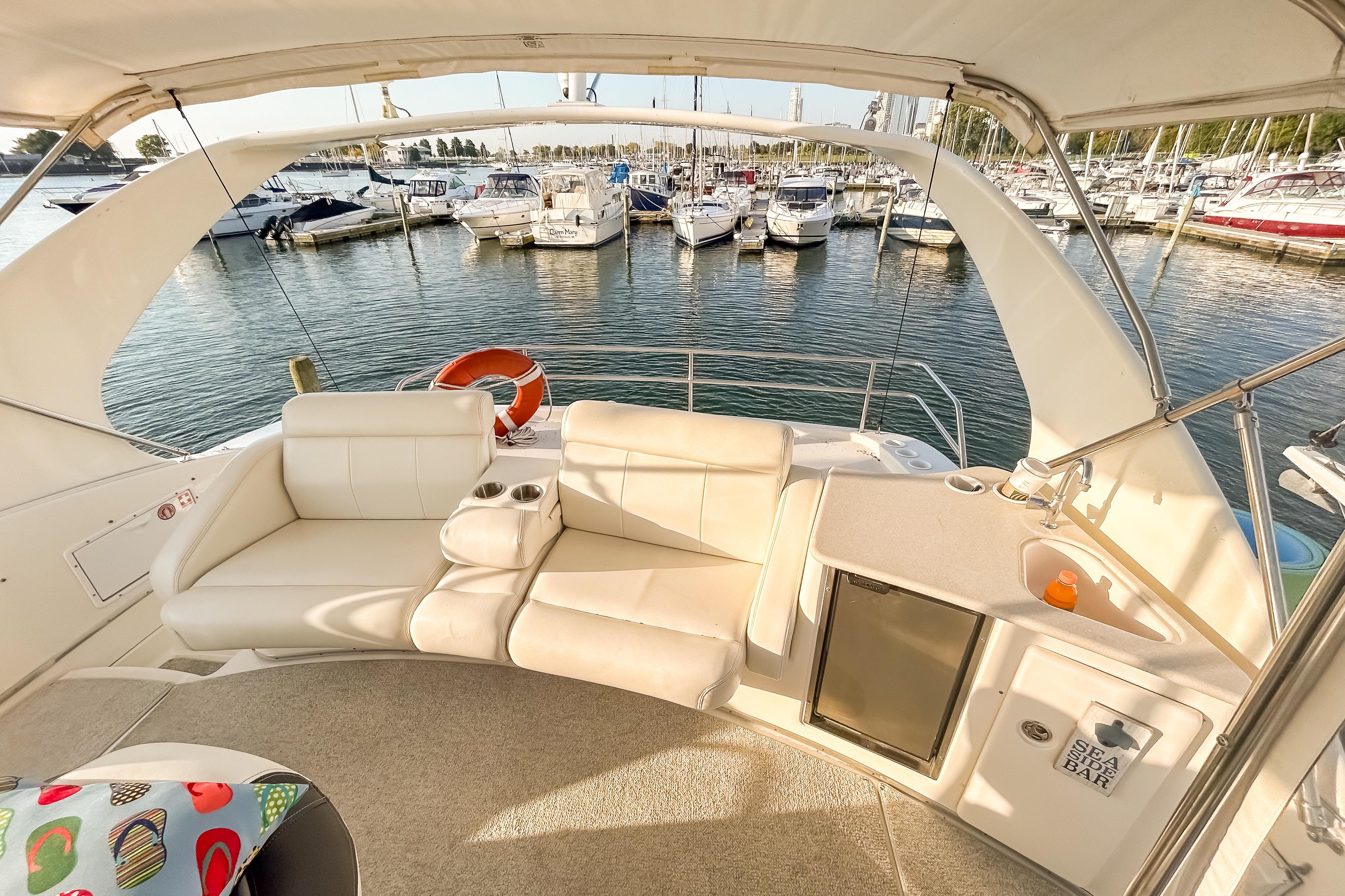 Luxurious 2003 Silverton 410 Sport Bridge yacht interior with seating and mini bar, docked at marina.