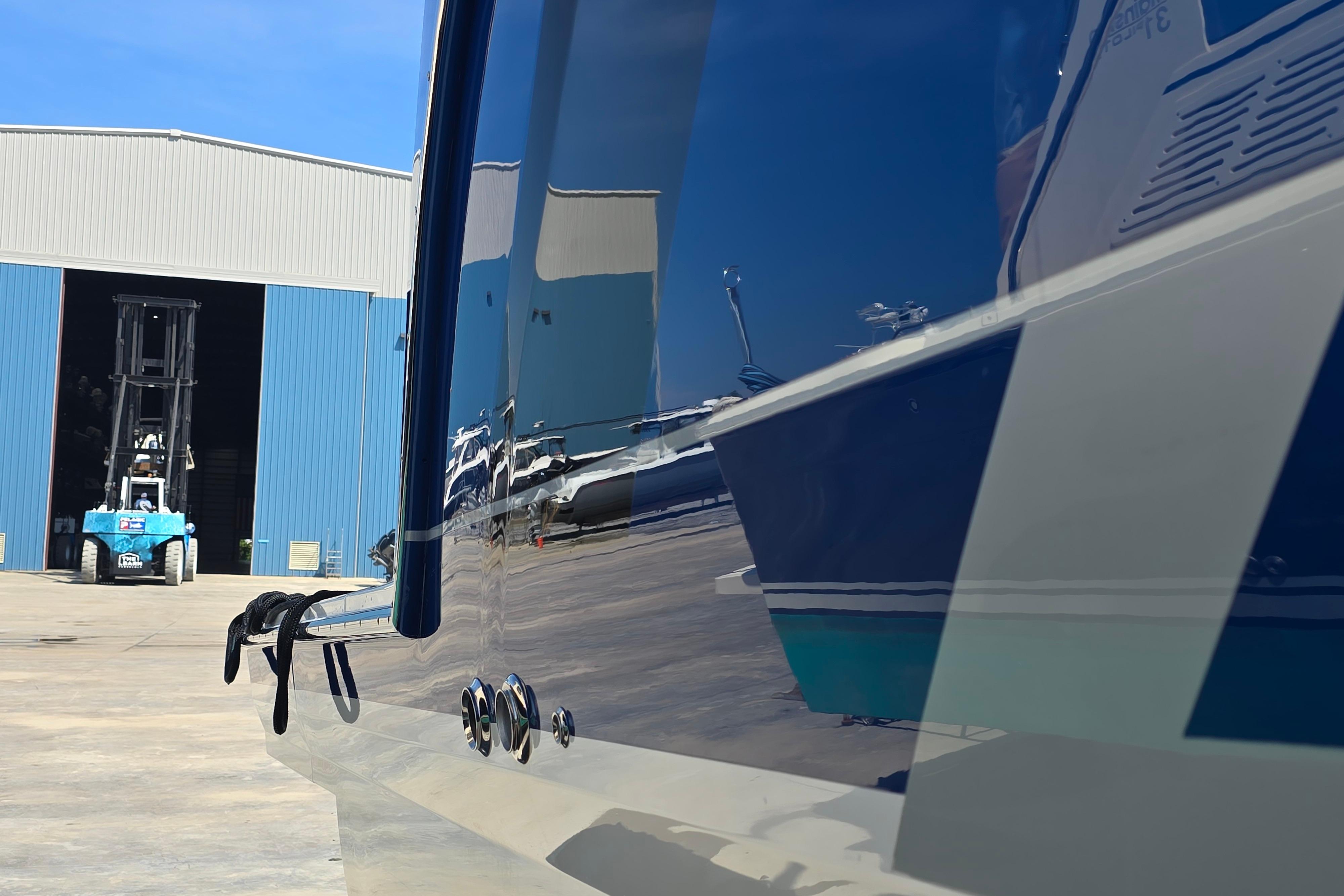 2025 Formula 380 Super Sport Crossover OB boat near a blue warehouse with forklift.