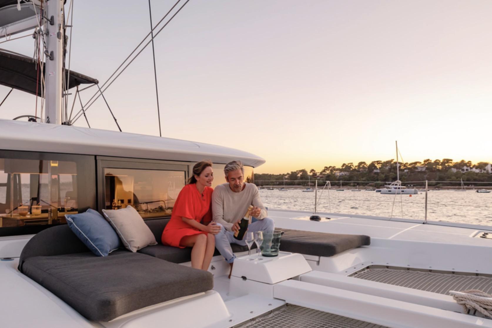 Couple relaxing on Lagoon 46 ICONIC yacht at sunset, 2026 model.