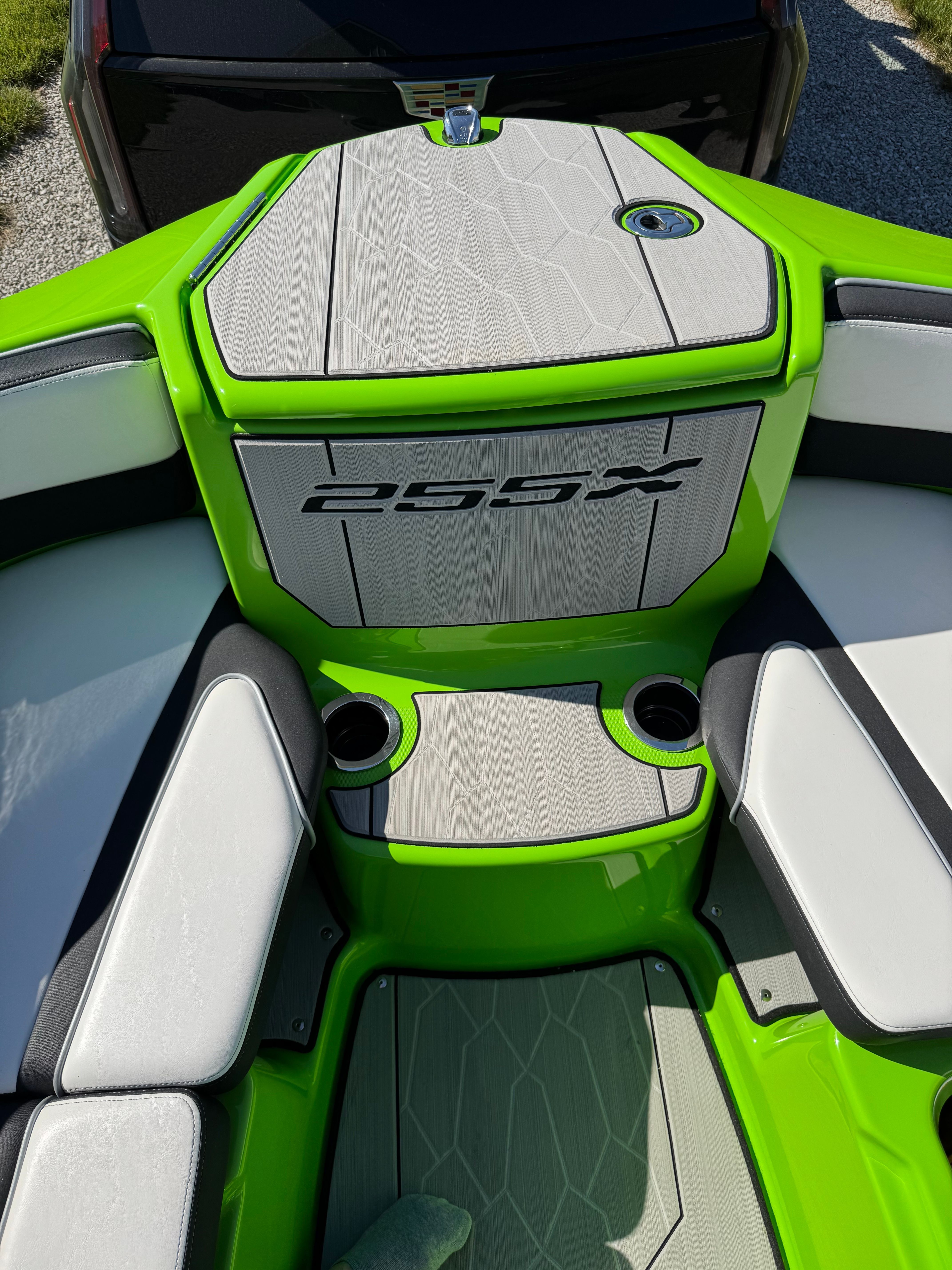 The image shows the cockpit of a 2022 Yamaha 255XD boat with bright green and gray upholstery.