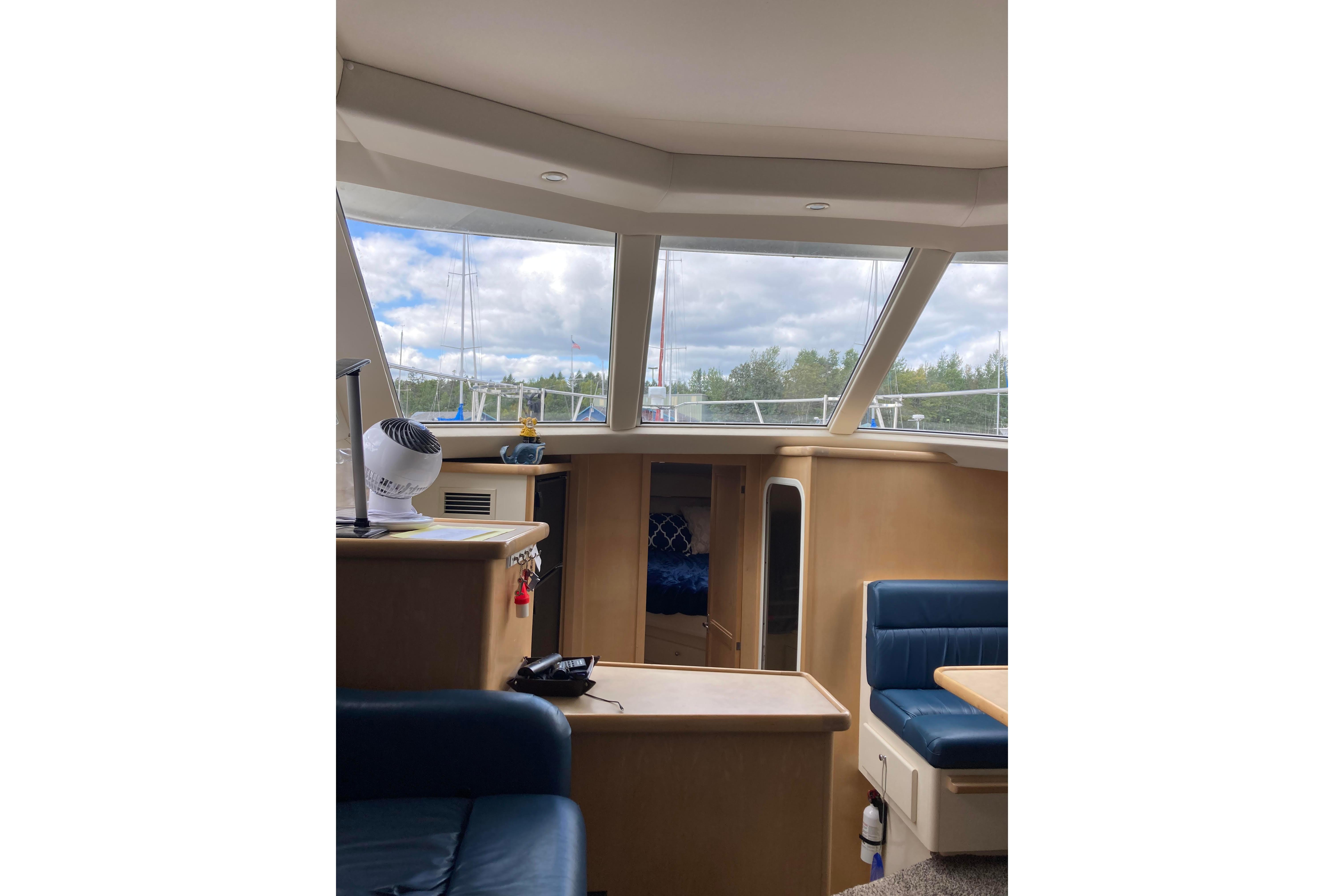 Interior of 1998 Carver 355 Aft Cabin Motor Yacht with large windows and seating area.