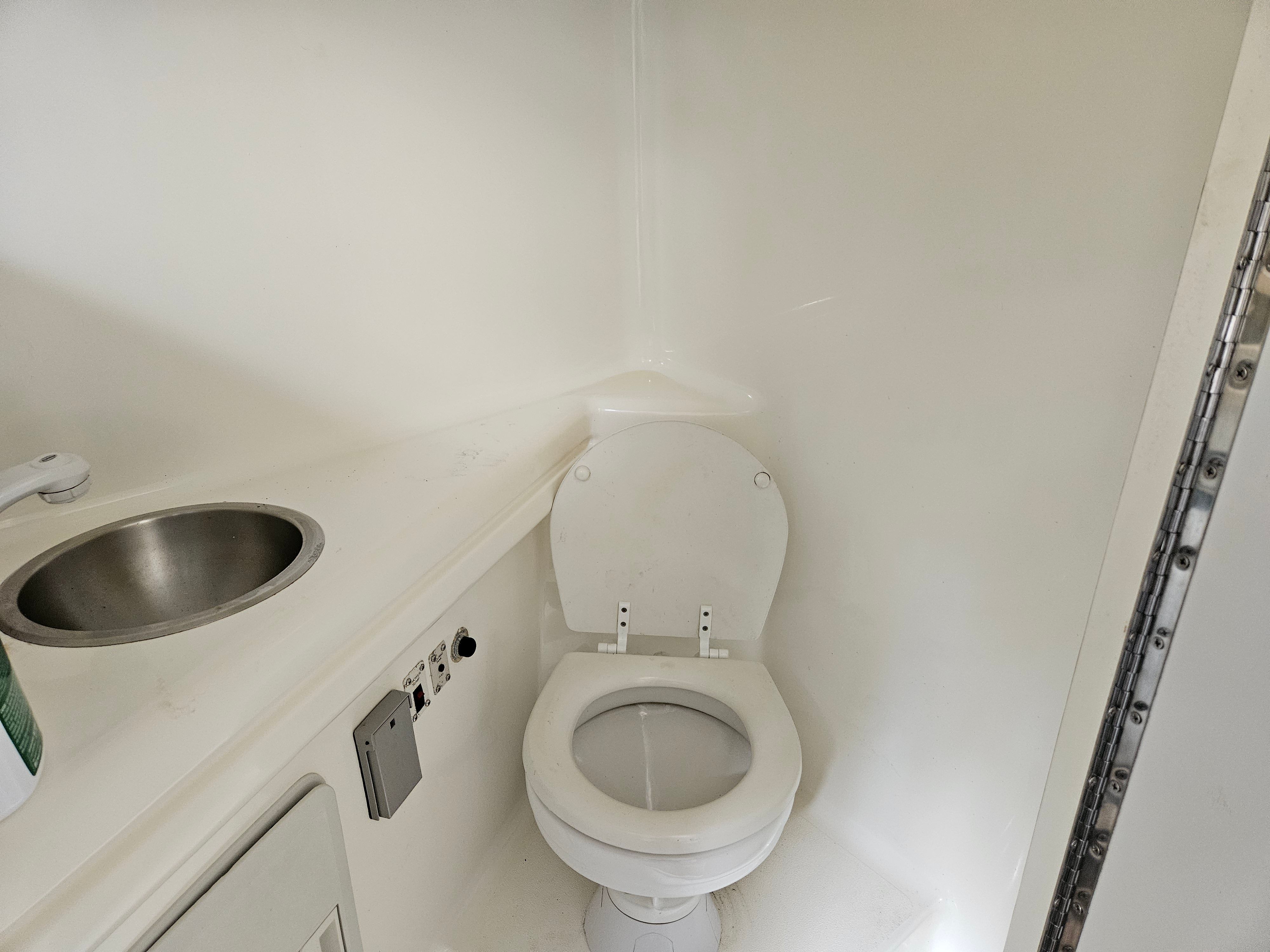 Interior of a 1998 Larson Cabrio 254 yacht with toilet and sink.