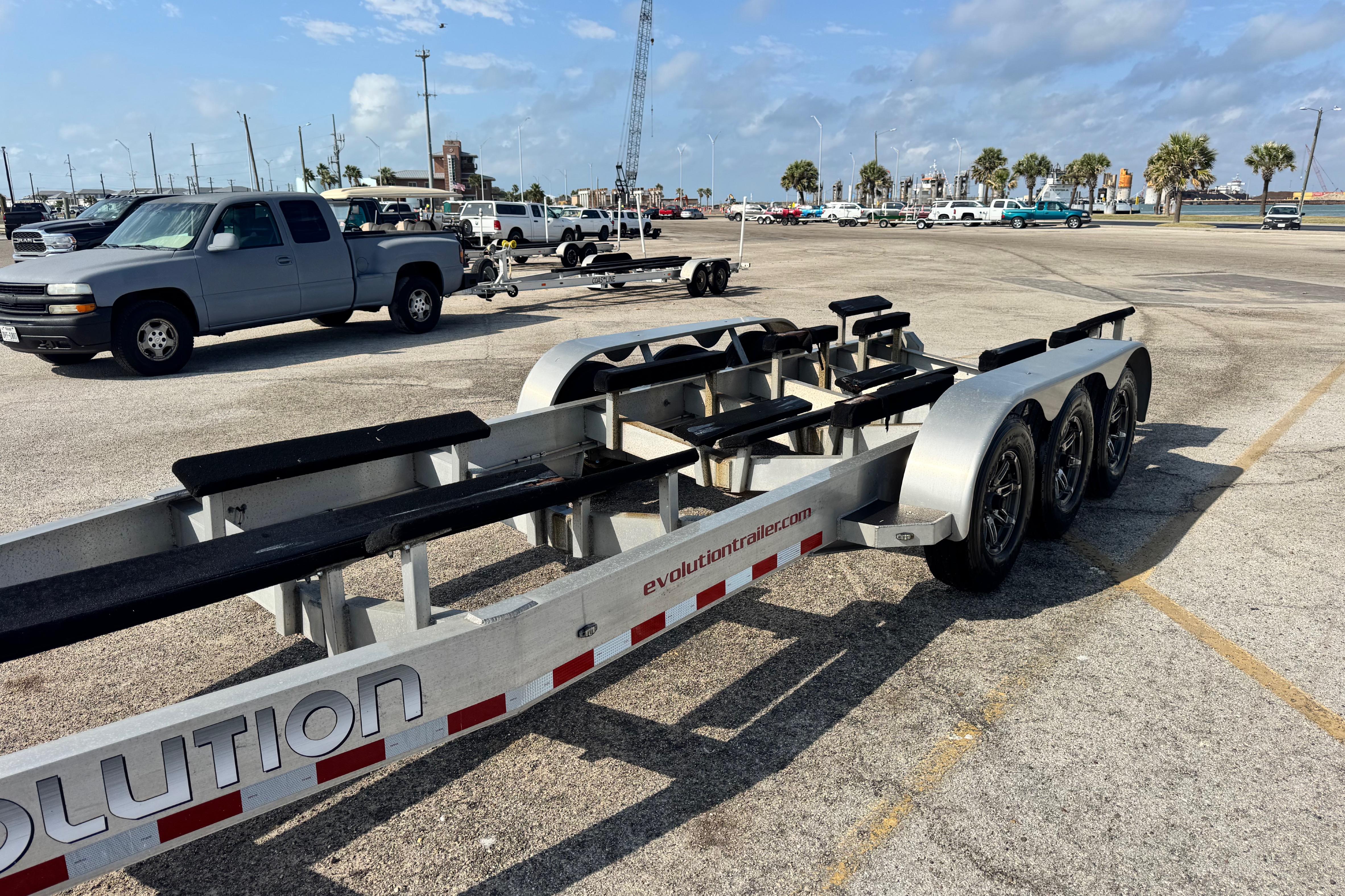 Trailer for 2018 Fountain 34 Center Console boat in parking lot with trucks.