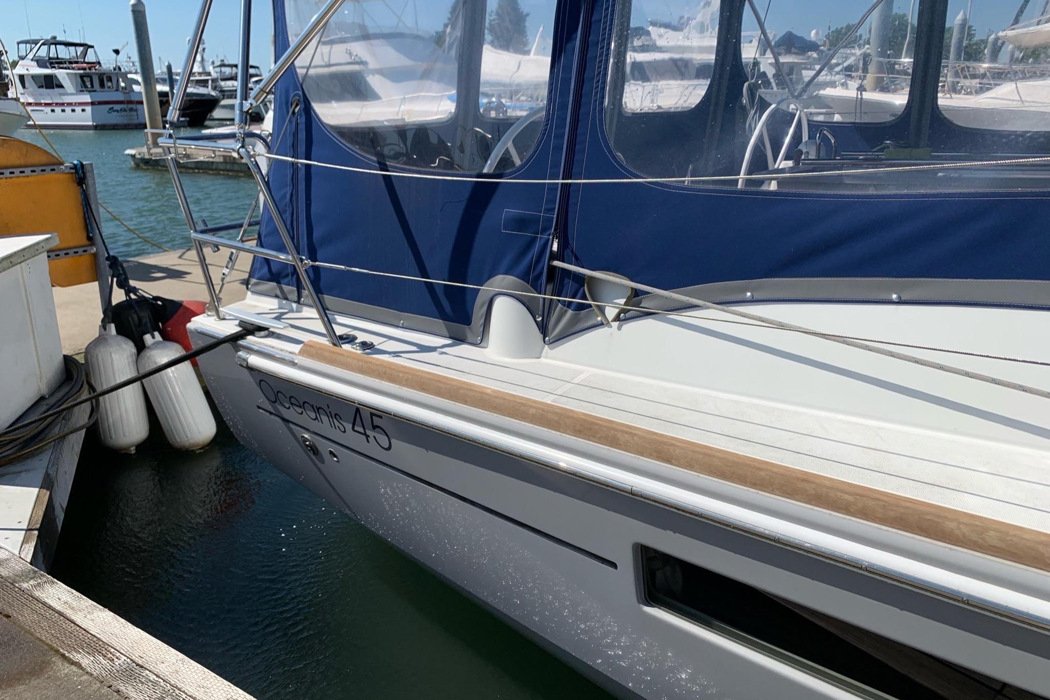2018 Beneteau Oceanis 45 sailboat docked with blue canopy and fenders.