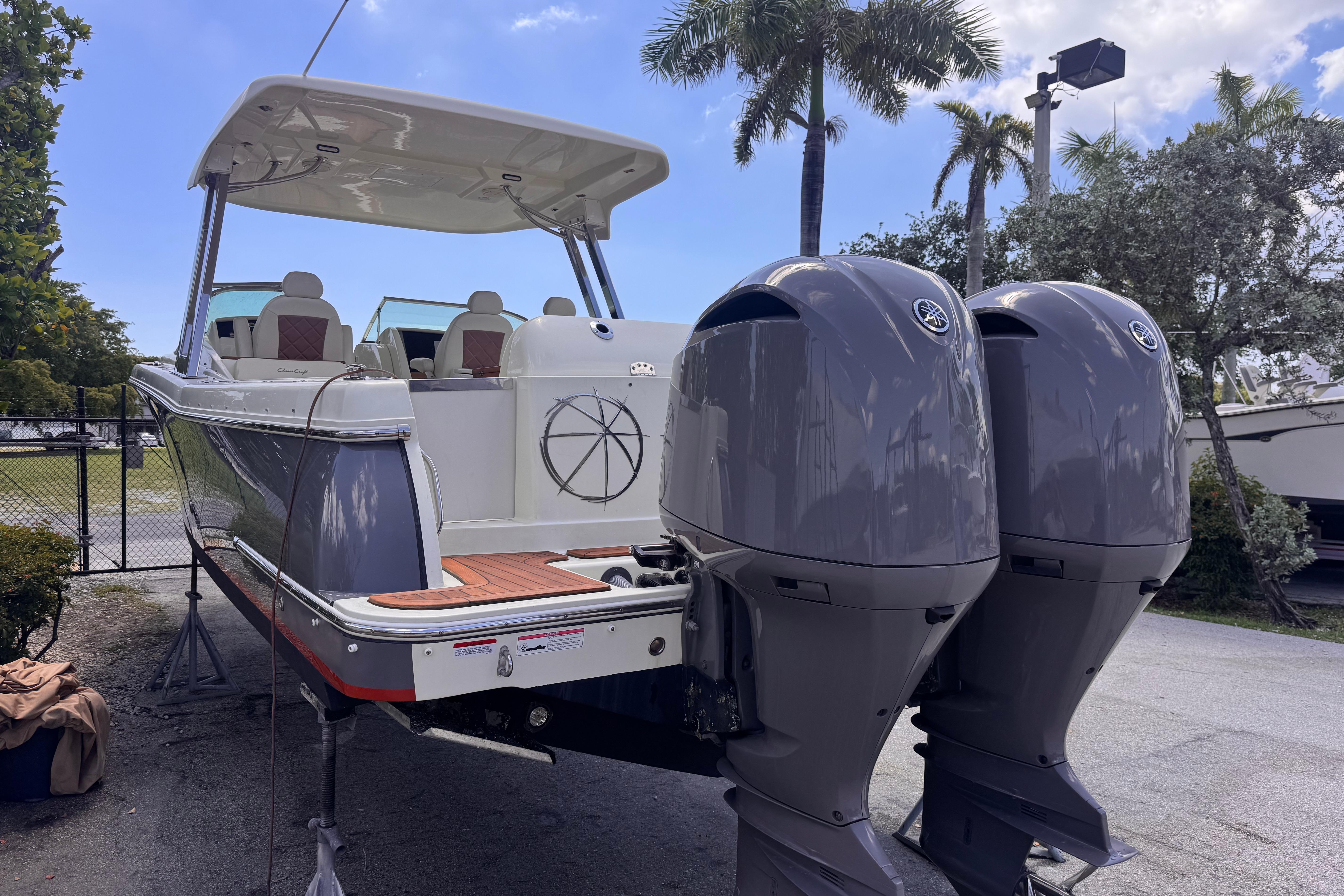 2018 Chris-Craft Calypso 30 boat with dual outboard engines, parked outdoors.