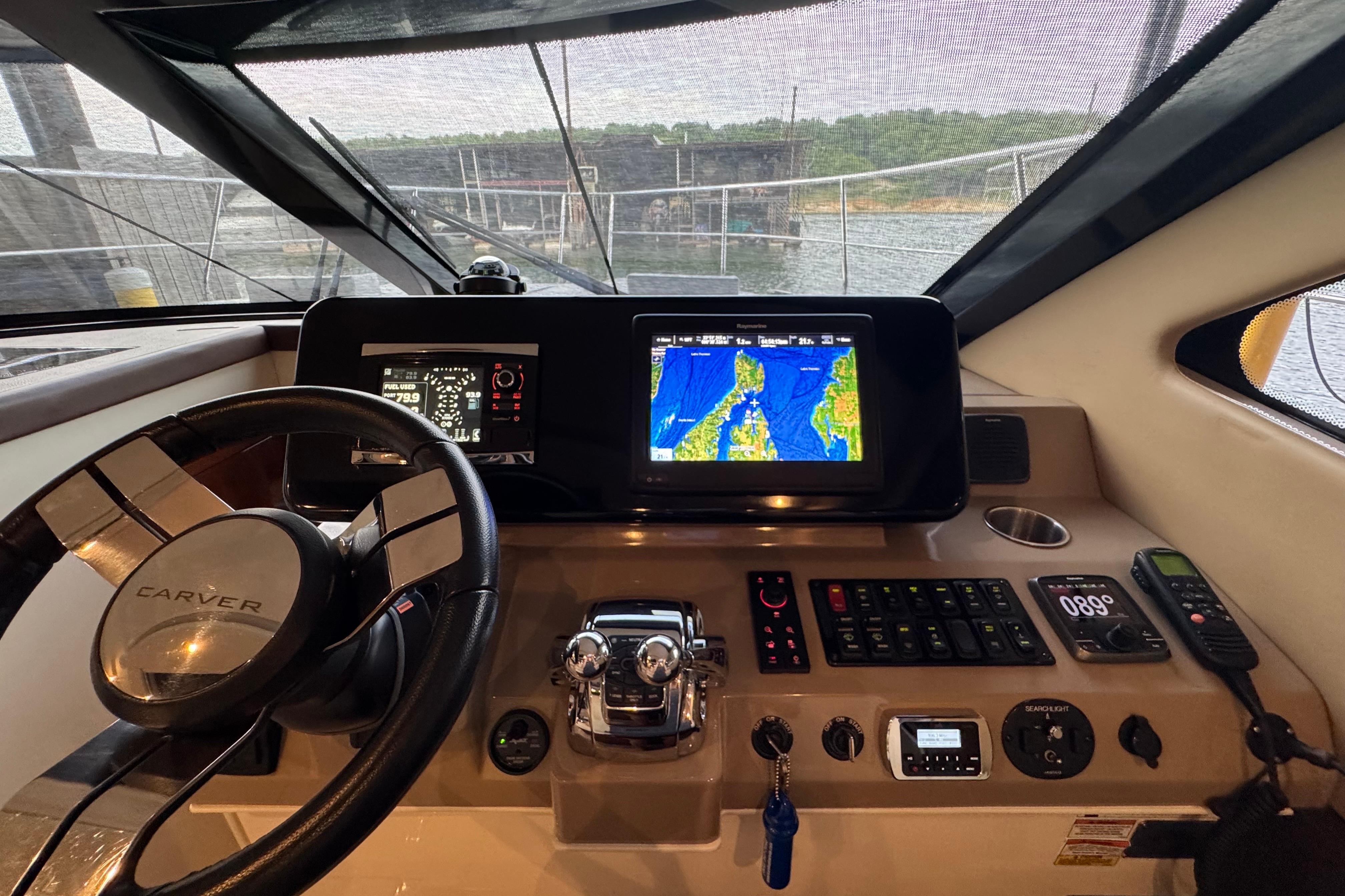Helm of 2016 Carver C37 Coupe with navigation screens and controls.