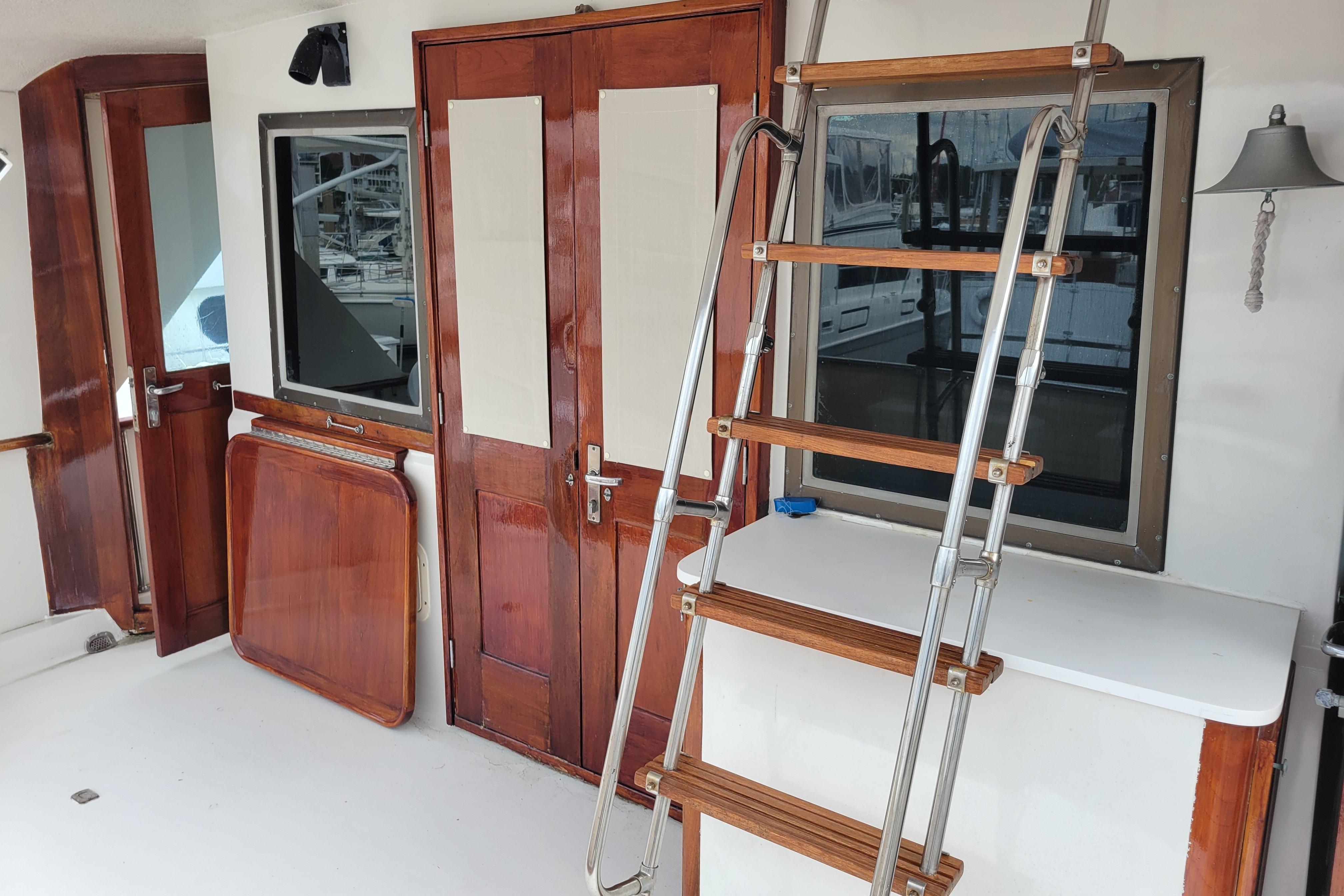 1980 Hatteras 53 Yacht Fisherman interior with wooden doors and ladder.