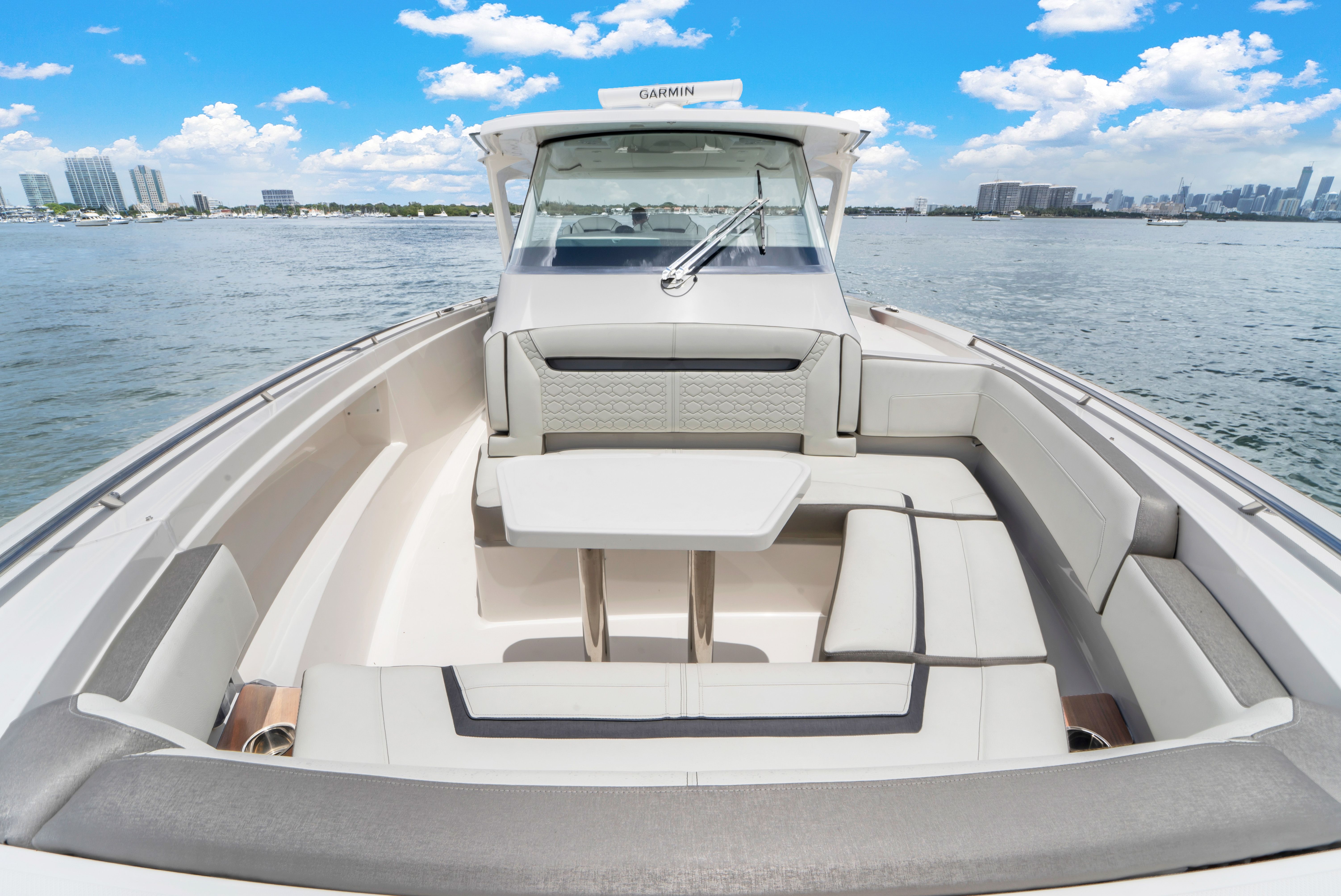 2023 Tiara Yachts 38 LS with a luxurious seating area and table on calm water.