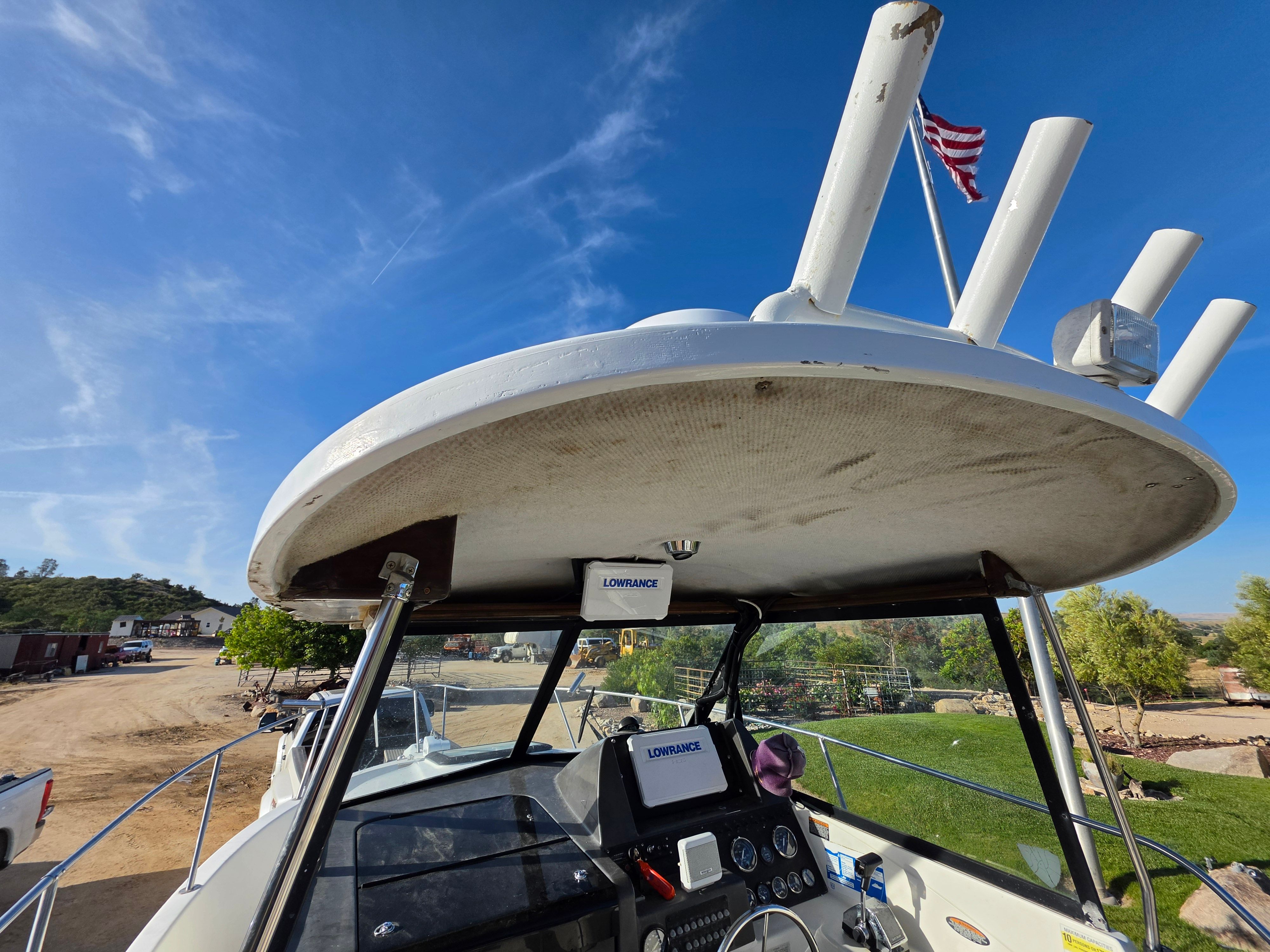 The boat is a 2001 Bayliner 2352 Trophy Walkaround. It features a spacious deck and modern helm.