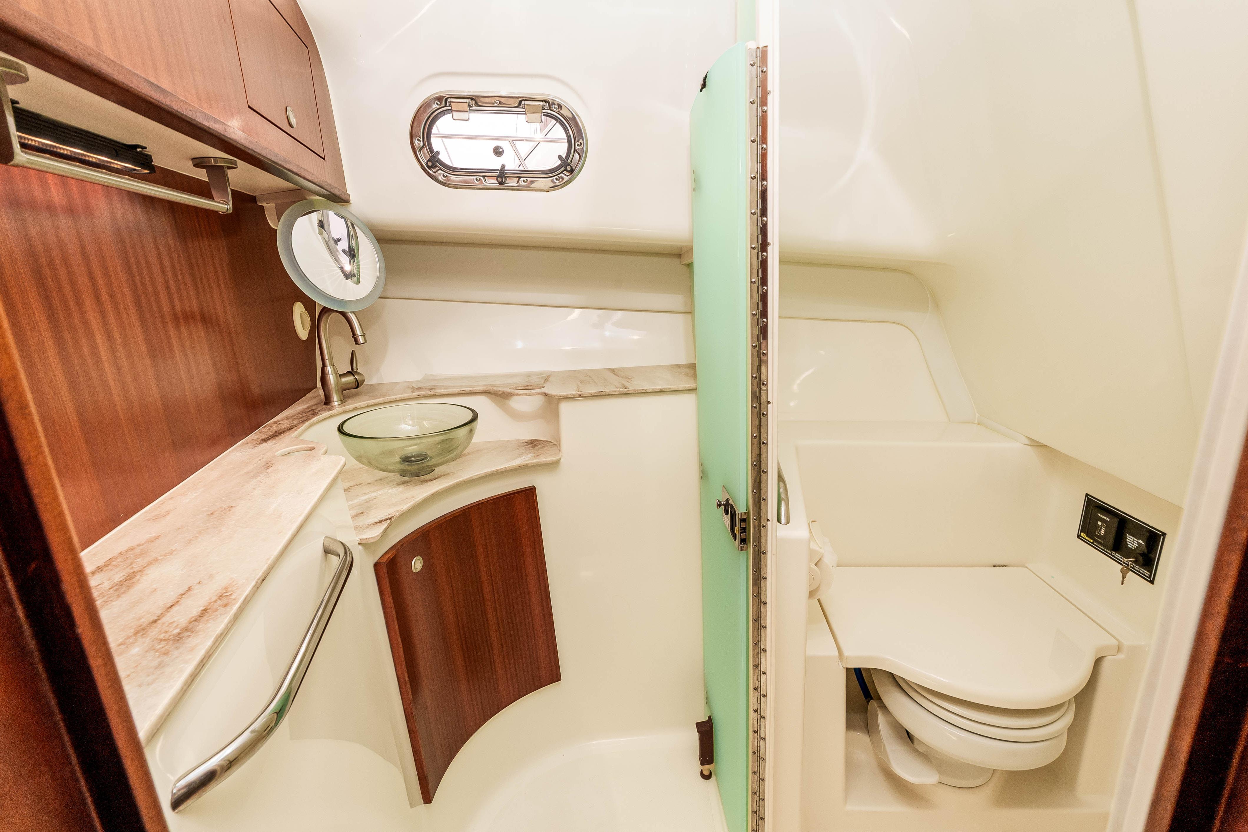 Luxurious bathroom in 2022 Pursuit OS 385 Offshore boat with modern fixtures and wood accents.
