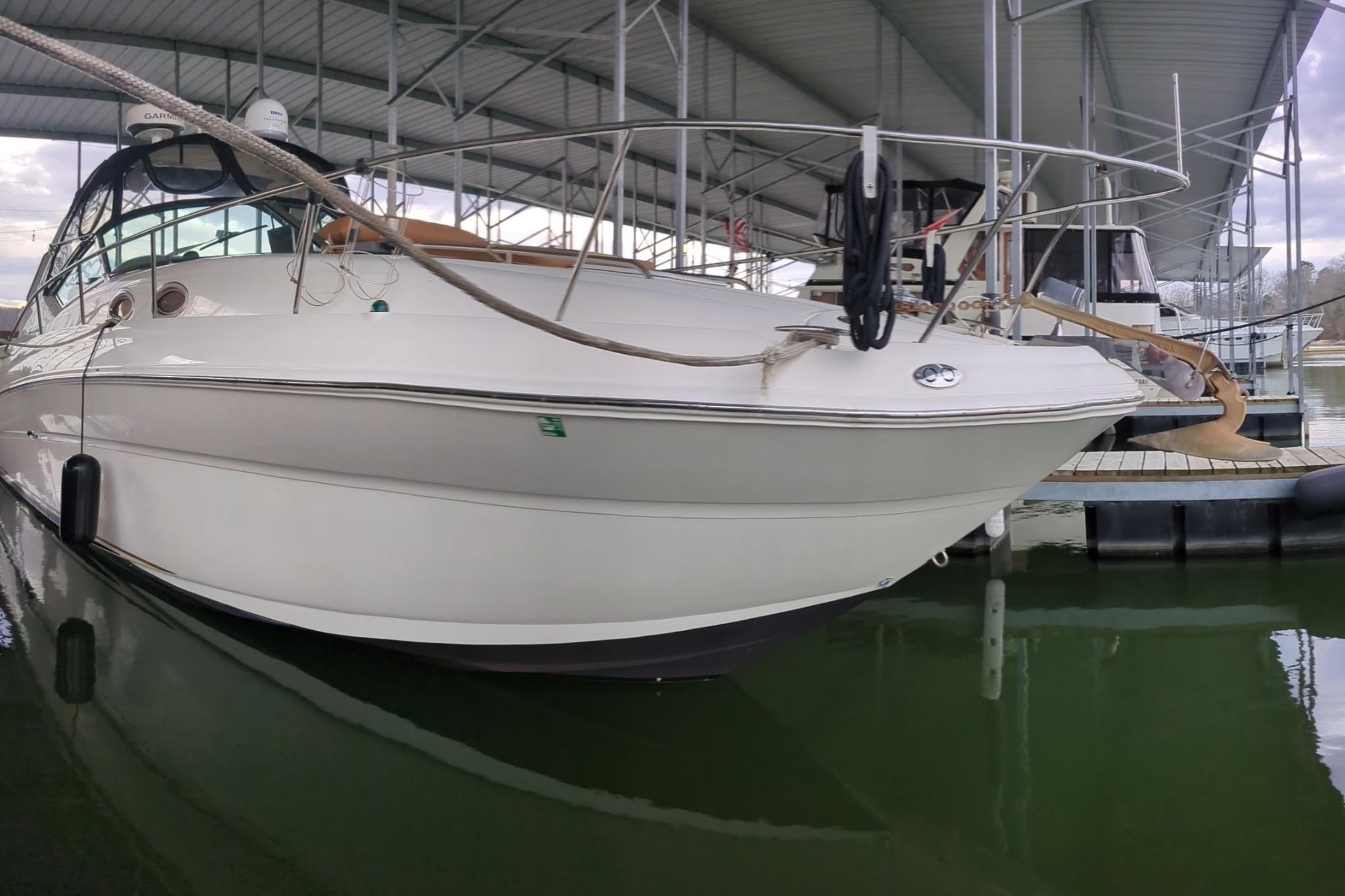2002 Sea Ray Sundancer 320 docked in a marina under a covered structure.