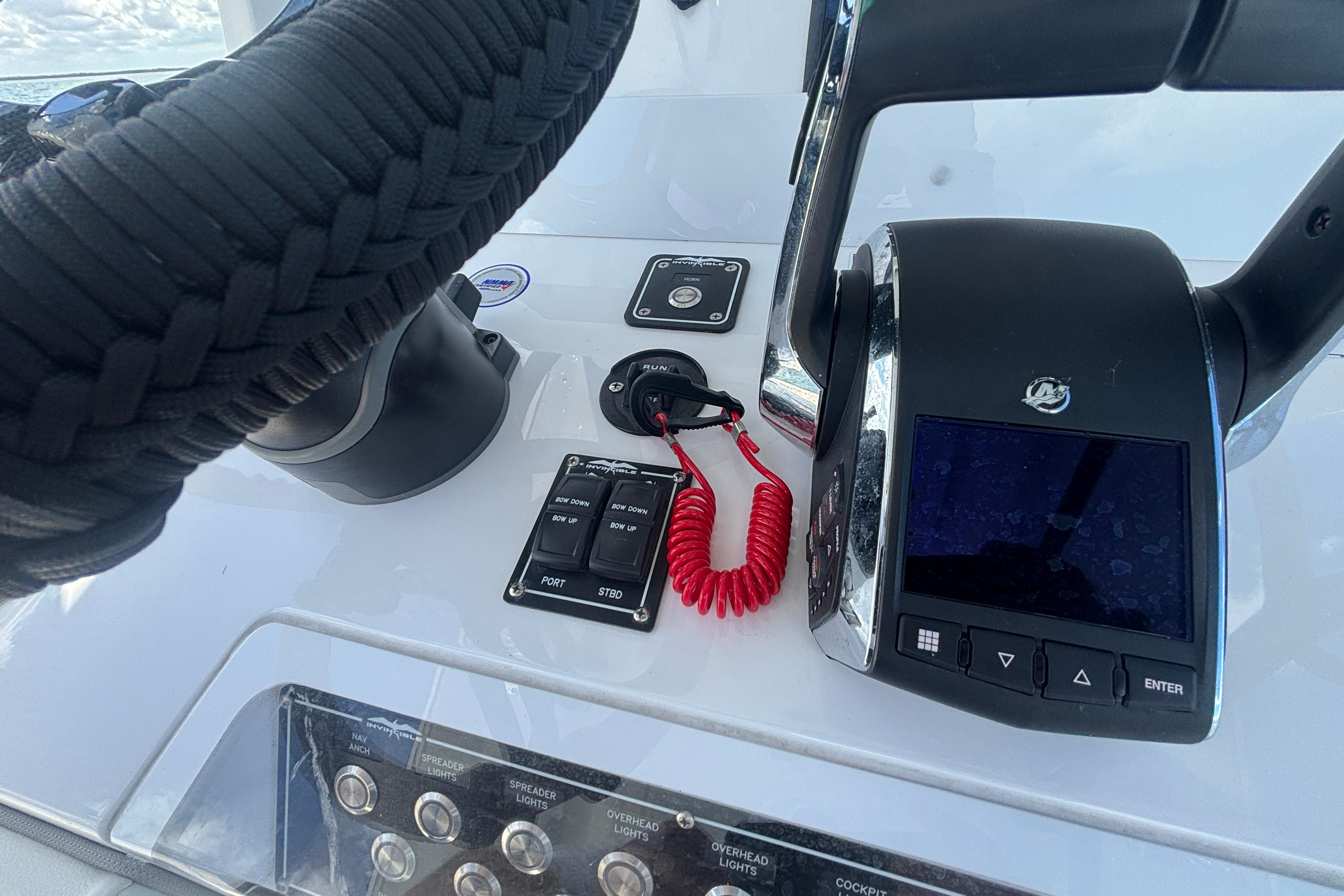 Control panel of 2024 Invincible 36 Open Fisherman boat with steering and throttle.