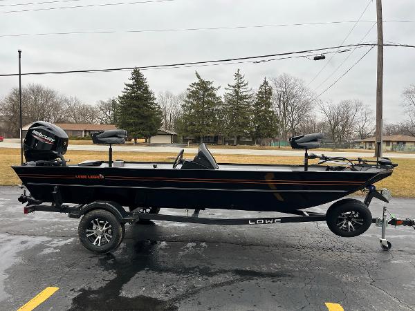 2024 Lowe Legacy boat on trailer, parked outdoors on a cloudy day.