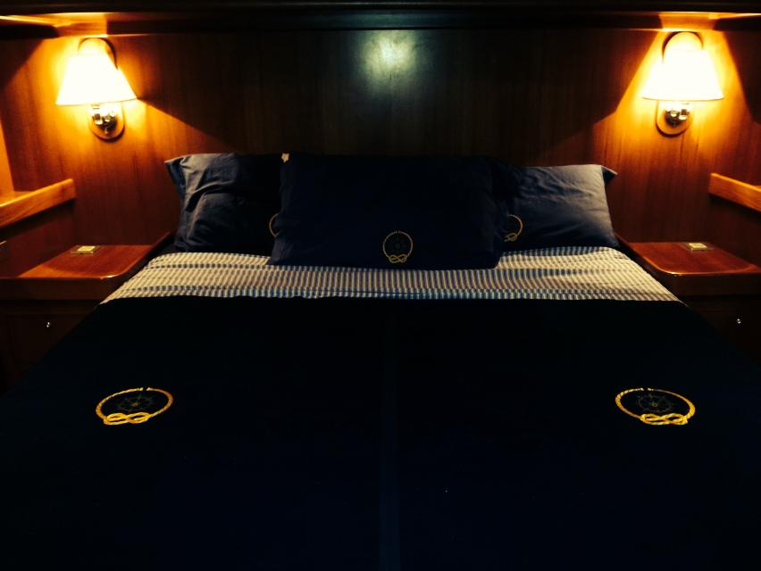 Luxurious cabin bedroom in 2010 North Wind 58 yacht, featuring elegant lighting and bedding.