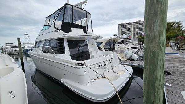 2000 Carver 450 Voyager Pilothouse yacht docked at marina, overcast sky.
