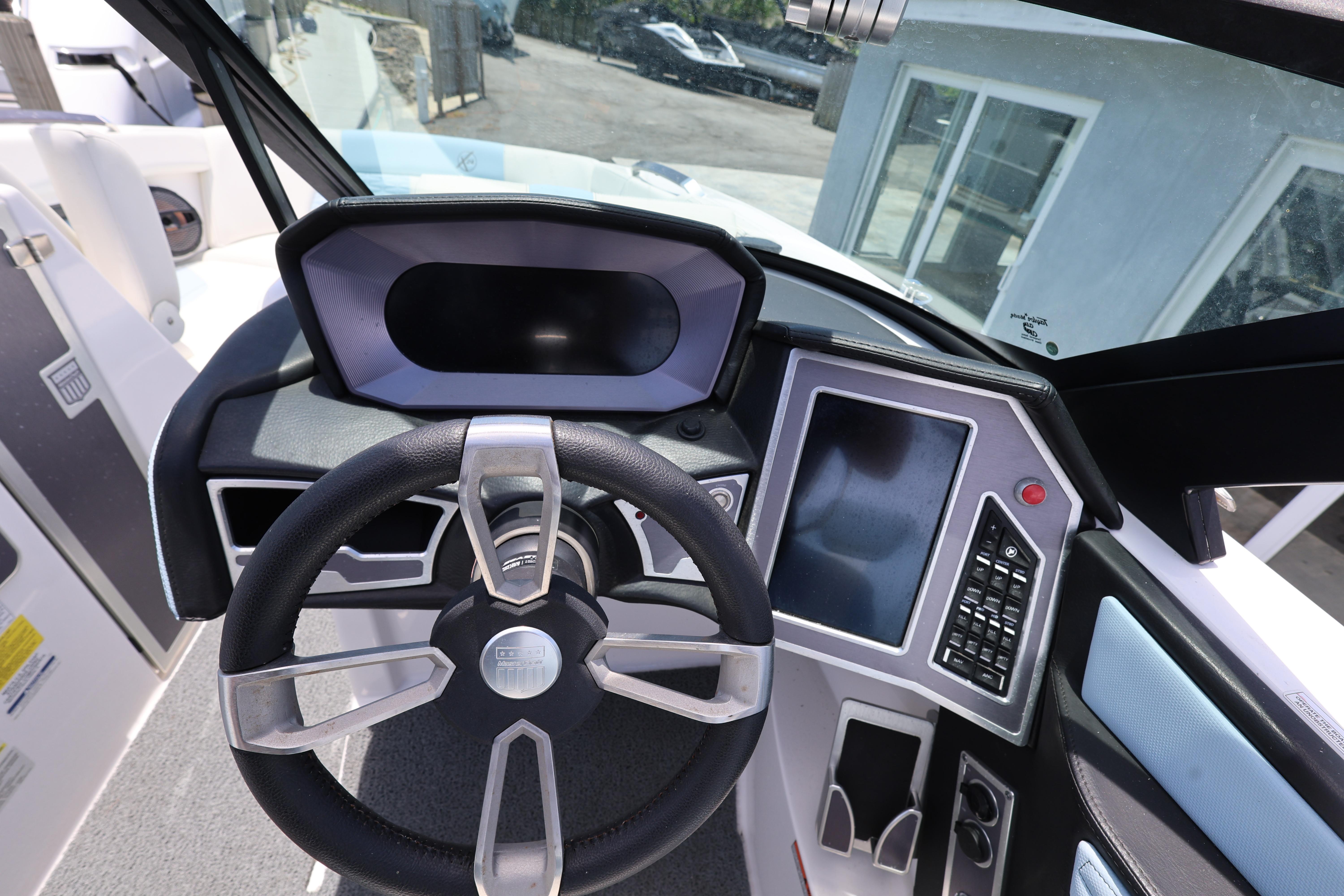 2023 MasterCraft X24 boat dashboard with steering wheel and control panel.