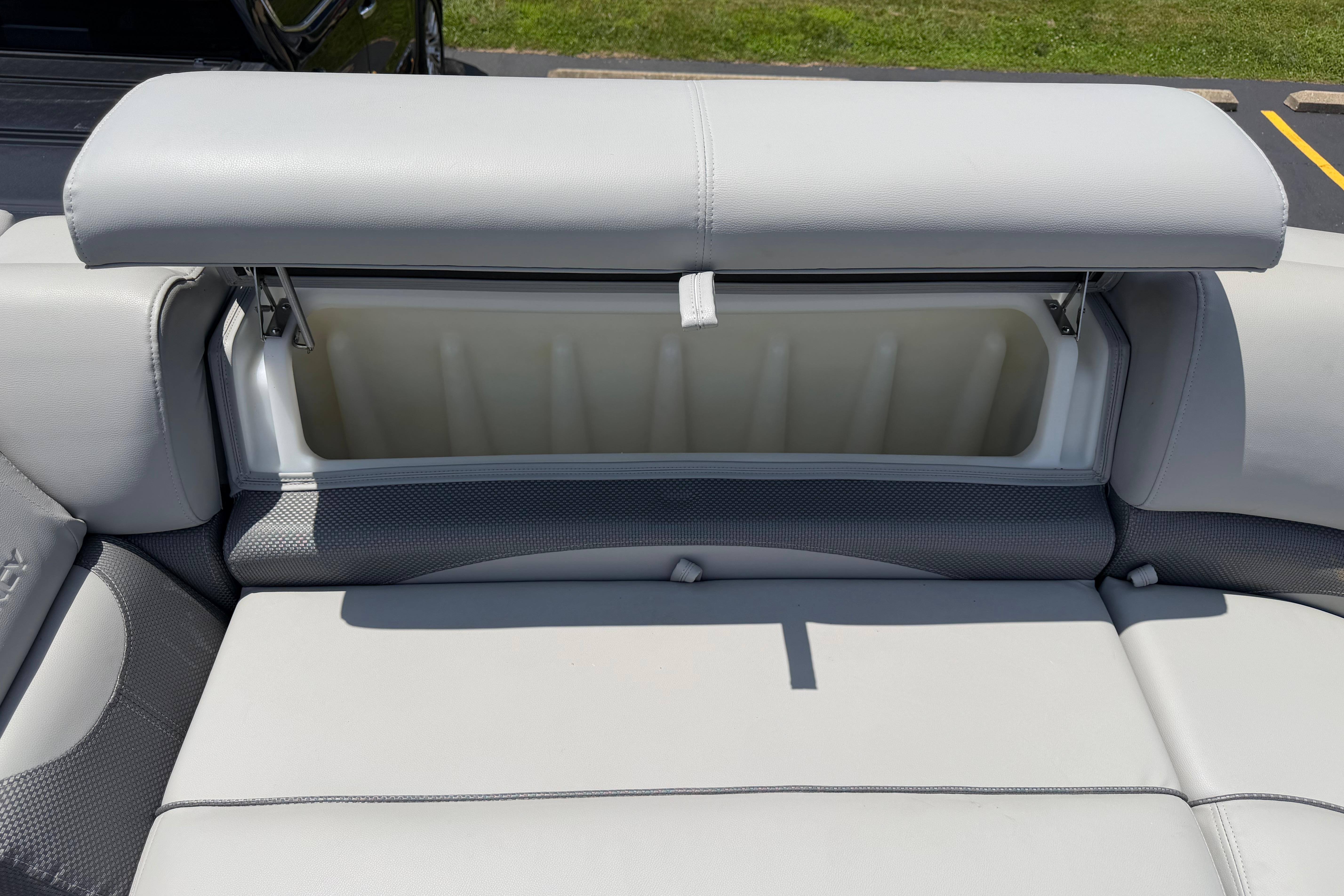 2019 Regency 230 DL3 boat seat storage compartment, open under sunny conditions.