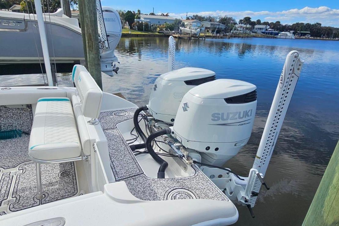 2002 Yellowfin 31 Center Console boat with twin Suzuki outboard motors docked by the water.