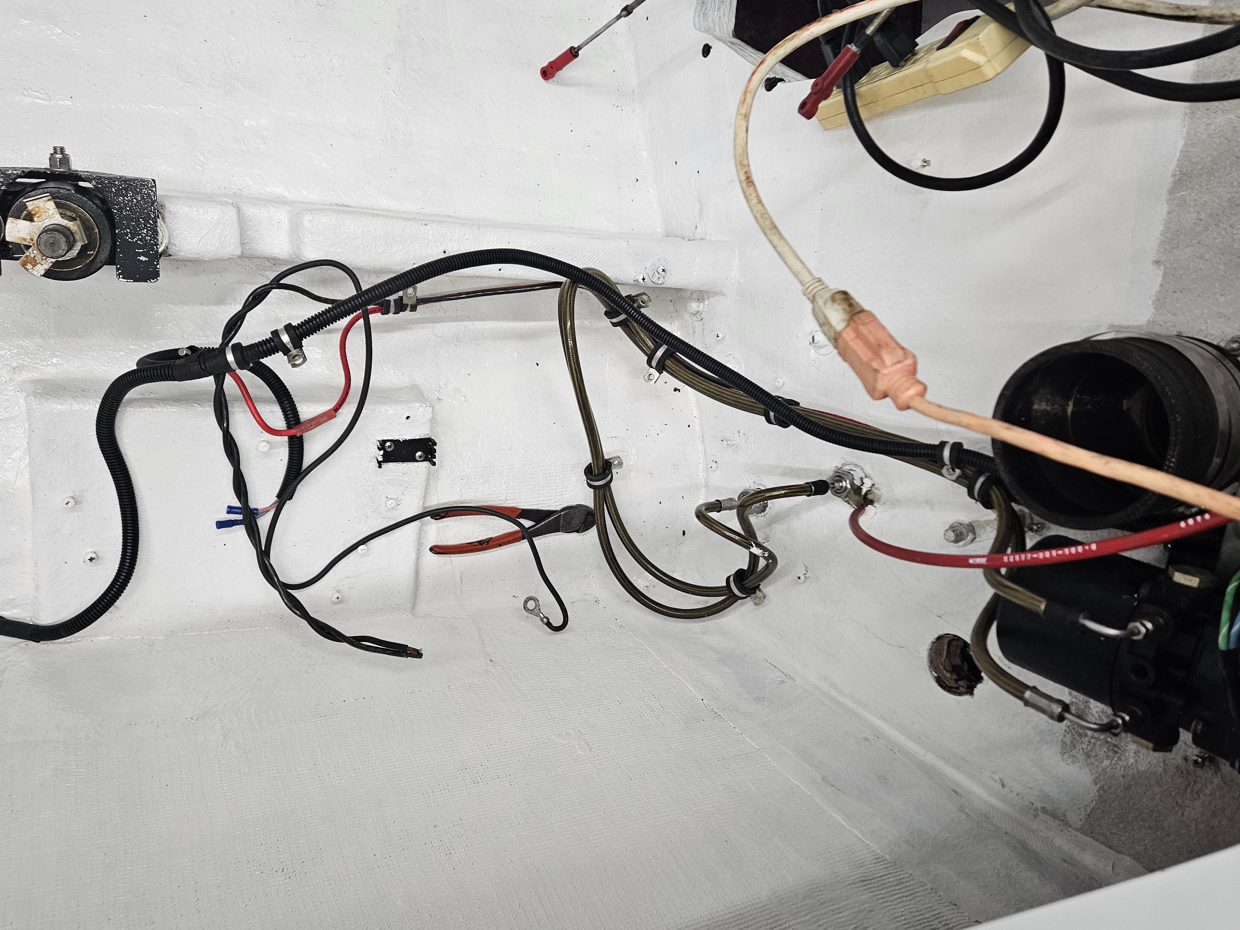 A view inside a boat's engine compartment with various cables and hoses.
