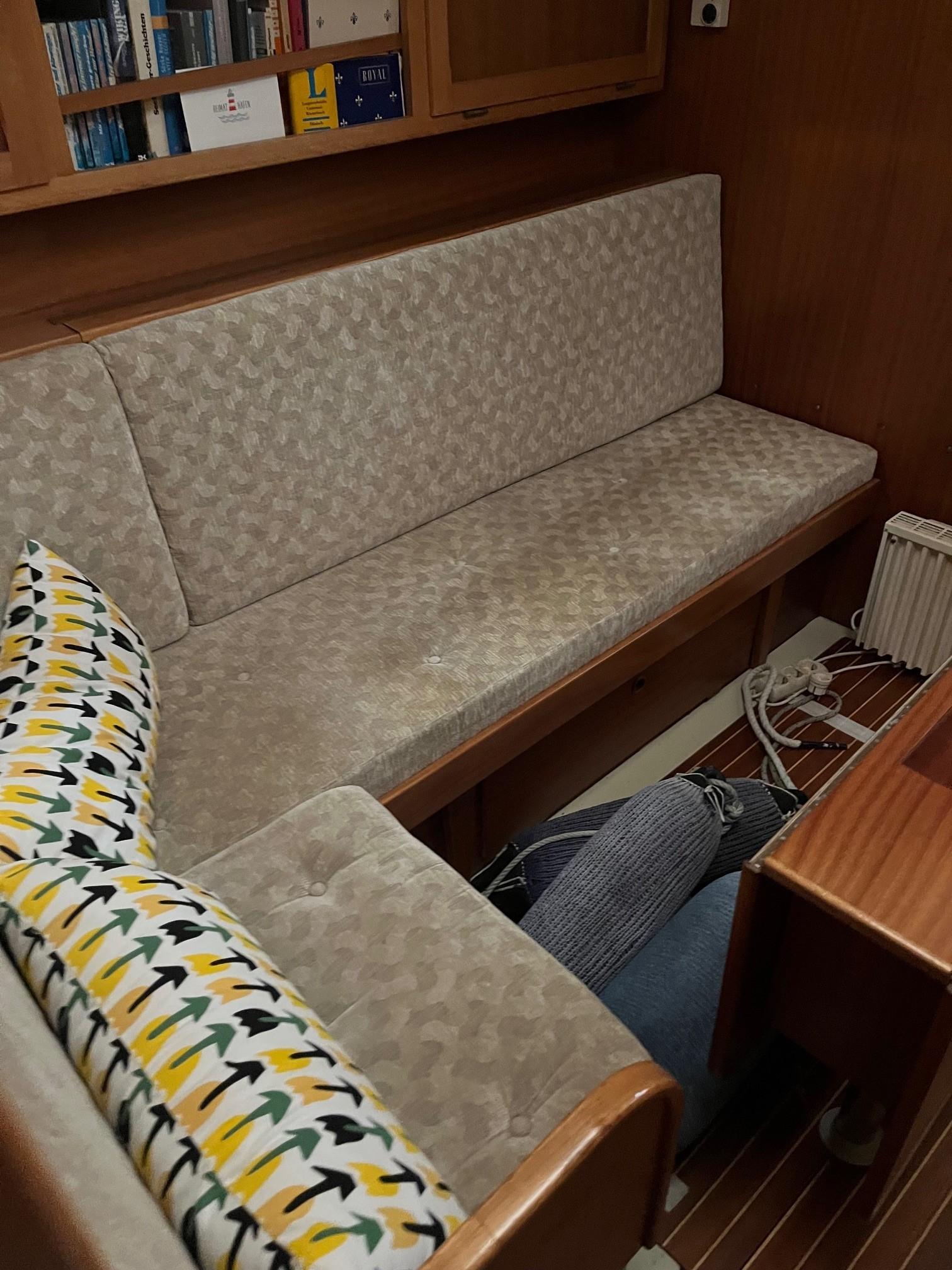 Cozy interior of 1980 LM 32 boat with patterned cushions and wooden accents.