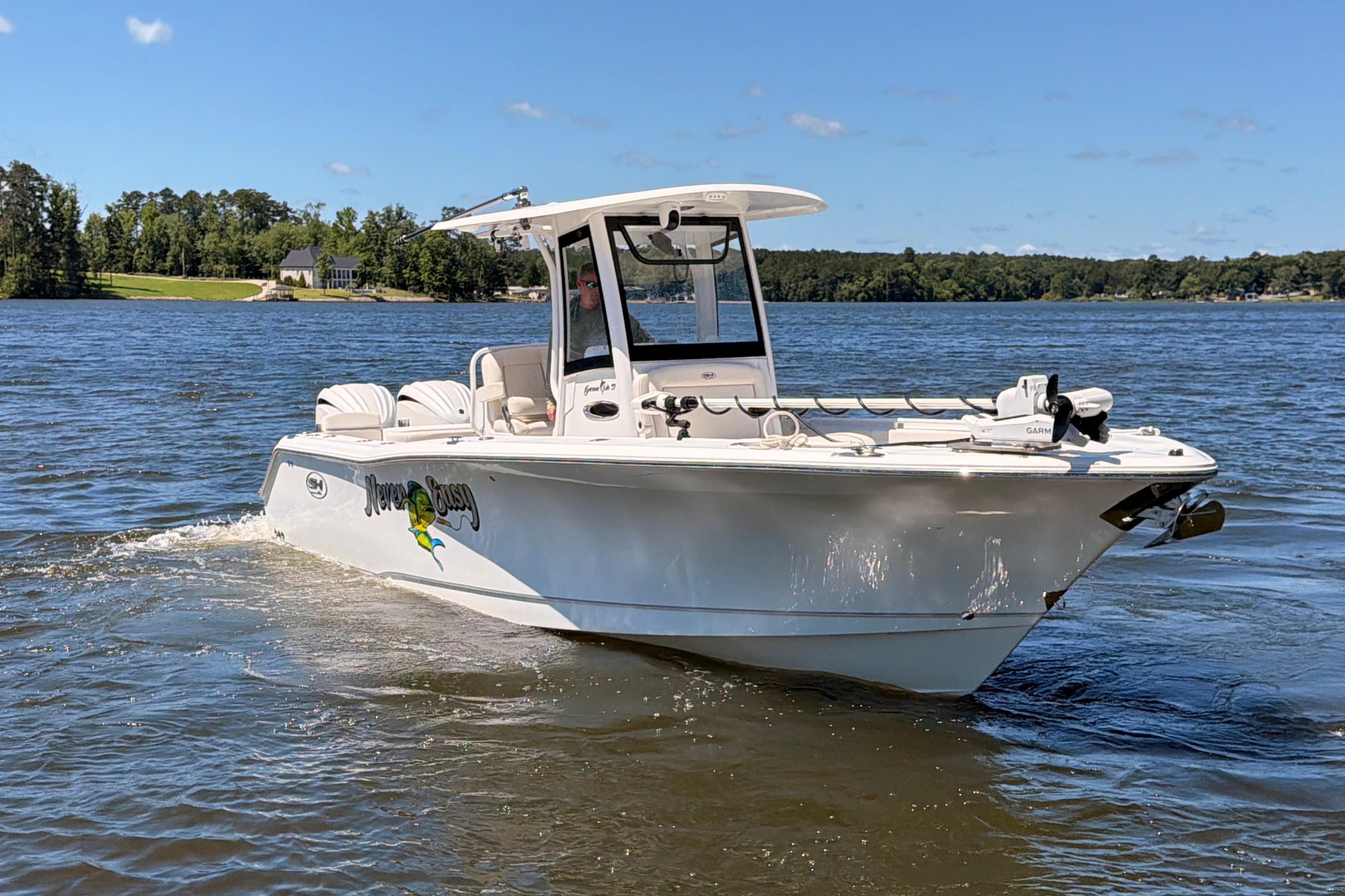 2024 Sea Hunt Gamefish 27 Coffin Box boat cruising on a sunny lake.