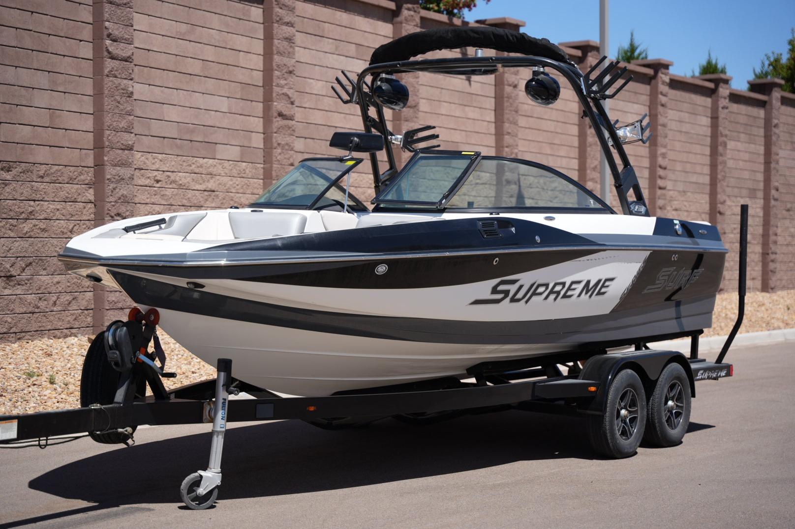 2016 Supreme S211 boat on trailer, parked outdoors.
