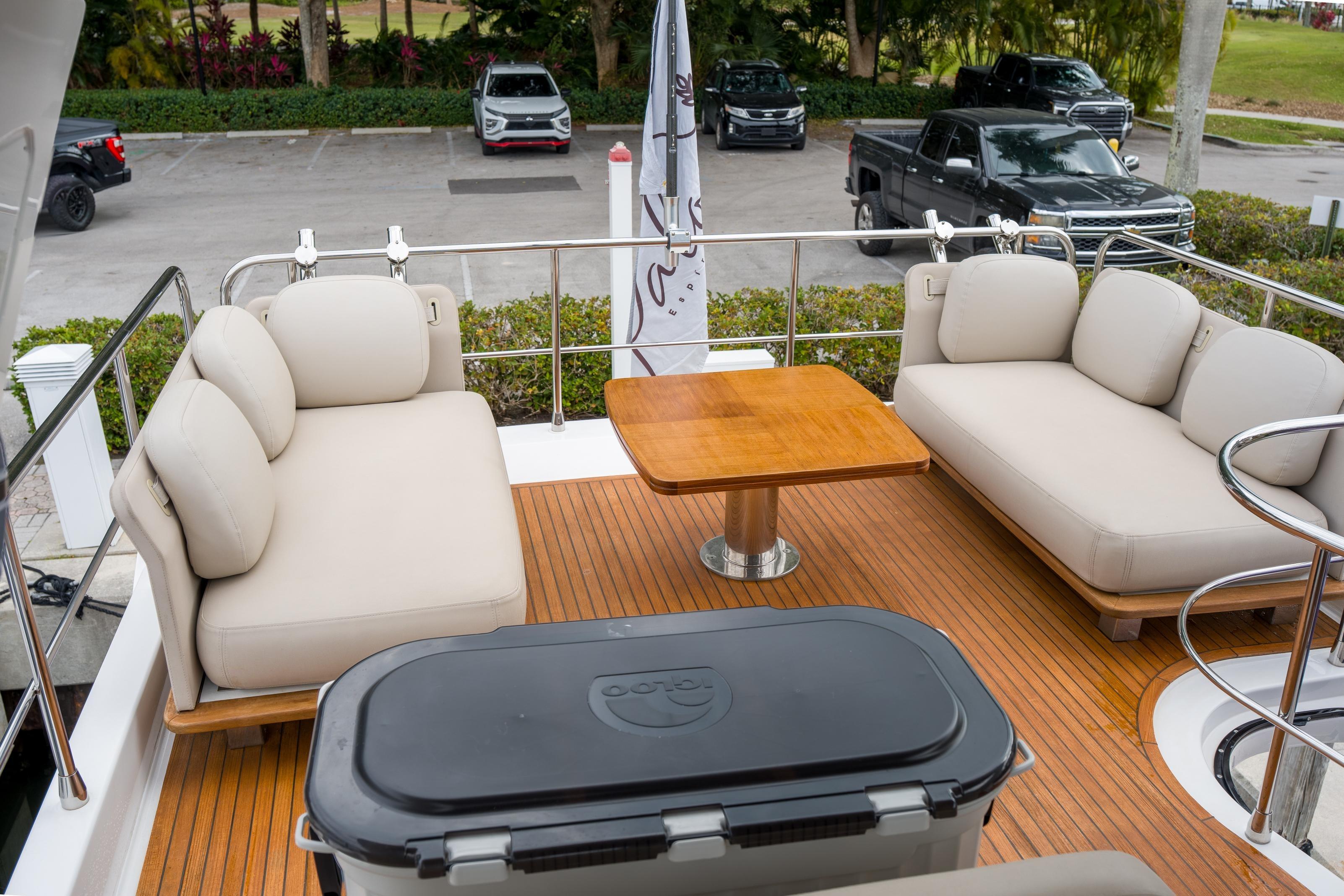 Luxurious 2019 Azimut Fly 50 yacht deck with plush seating and wooden table.