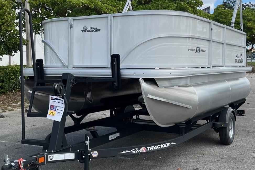 2026 Sun Tracker Party Barge 16 DLX pontoon boat on trailer, parked outdoors.