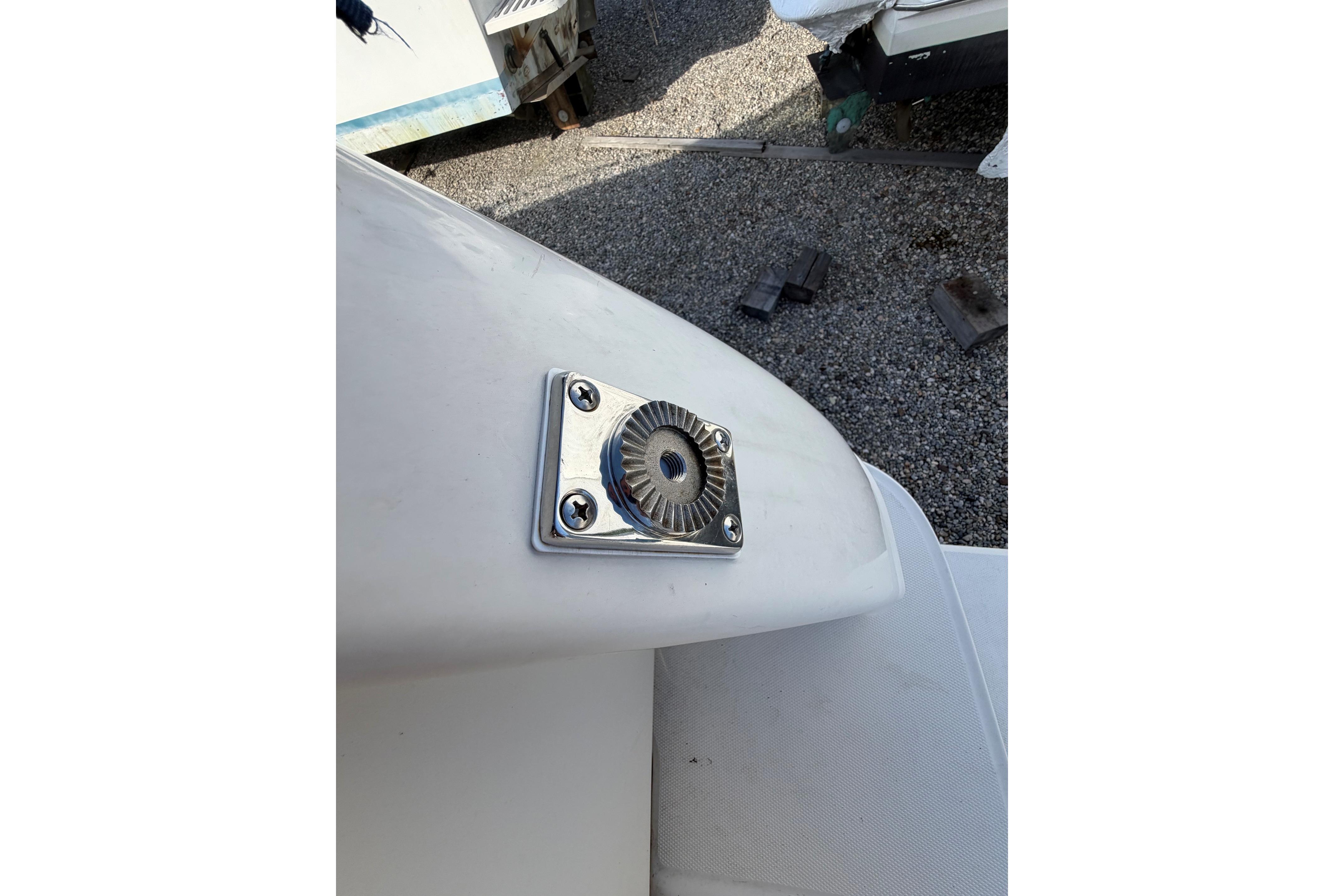Close-up of a 2000 Sea Ray 240 Sundancer boat's metal fitting on white surface.