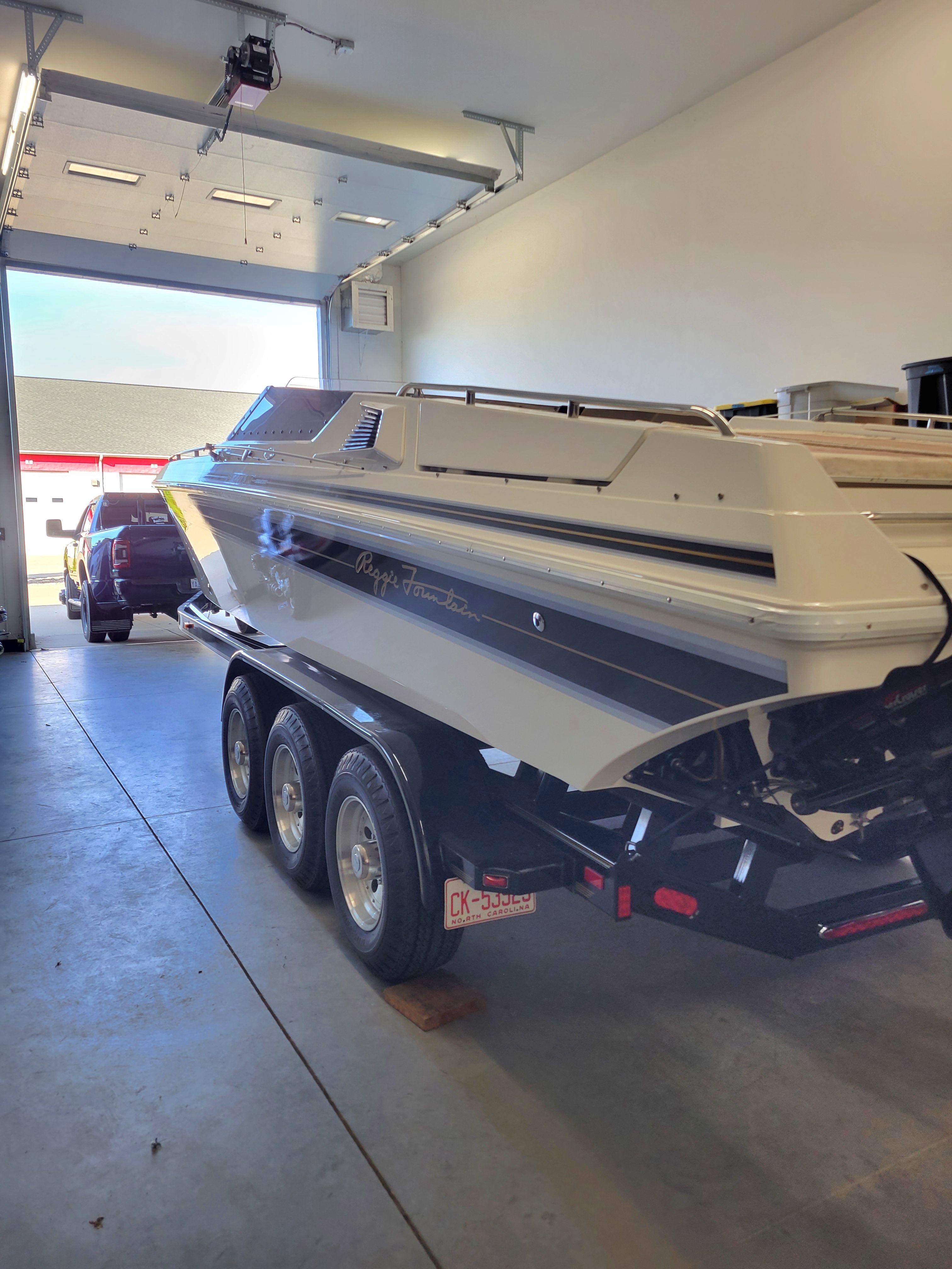 1992 Fountain Fever boat on trailer in garage, rear view.