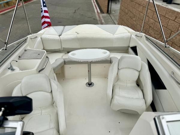 2006 Larson LXi 248 boat interior with white seating and table, American flag visible.