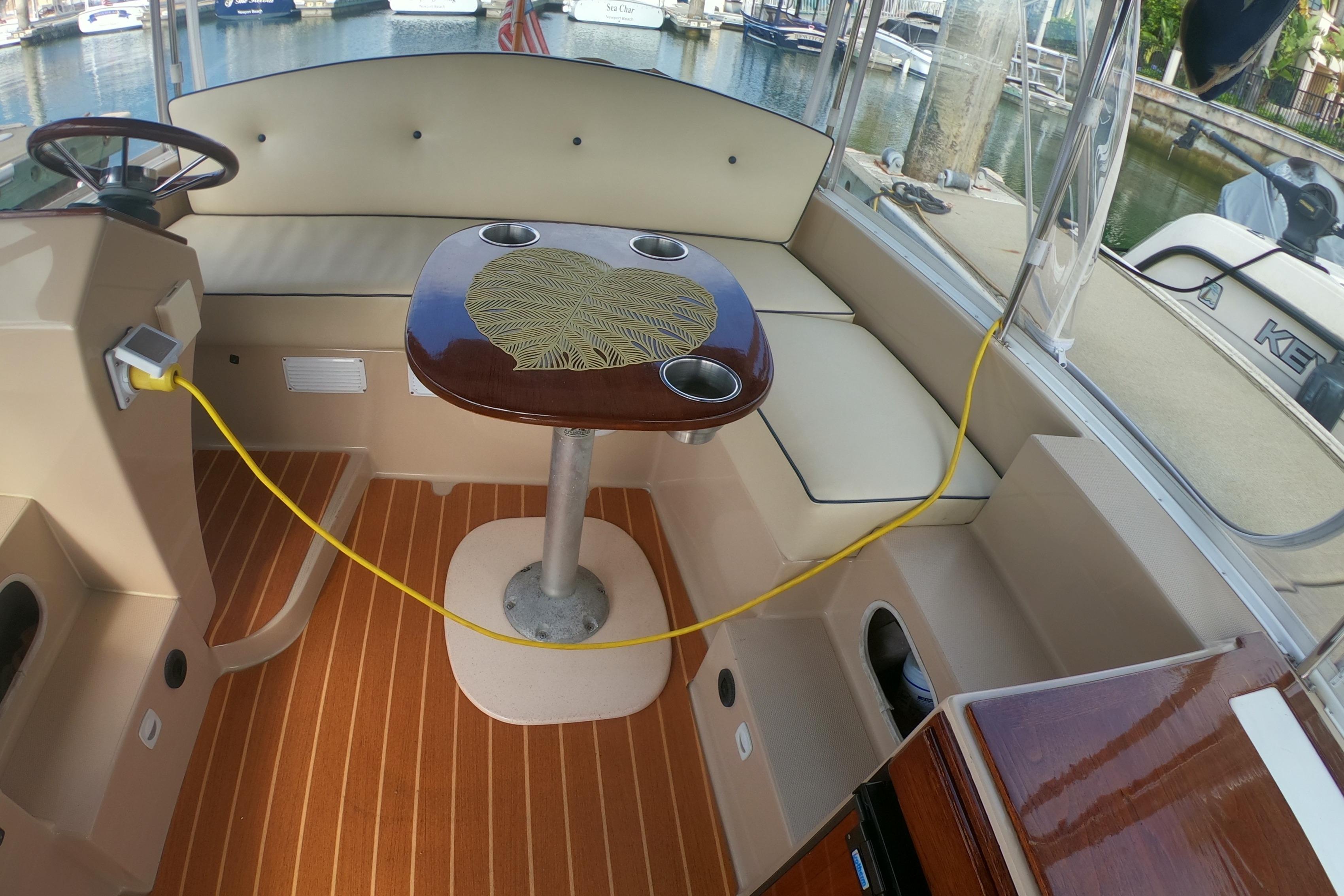 Interior of a 2008 Duffy Snug Harbor 18 boat with cushioned seating and a wooden table.