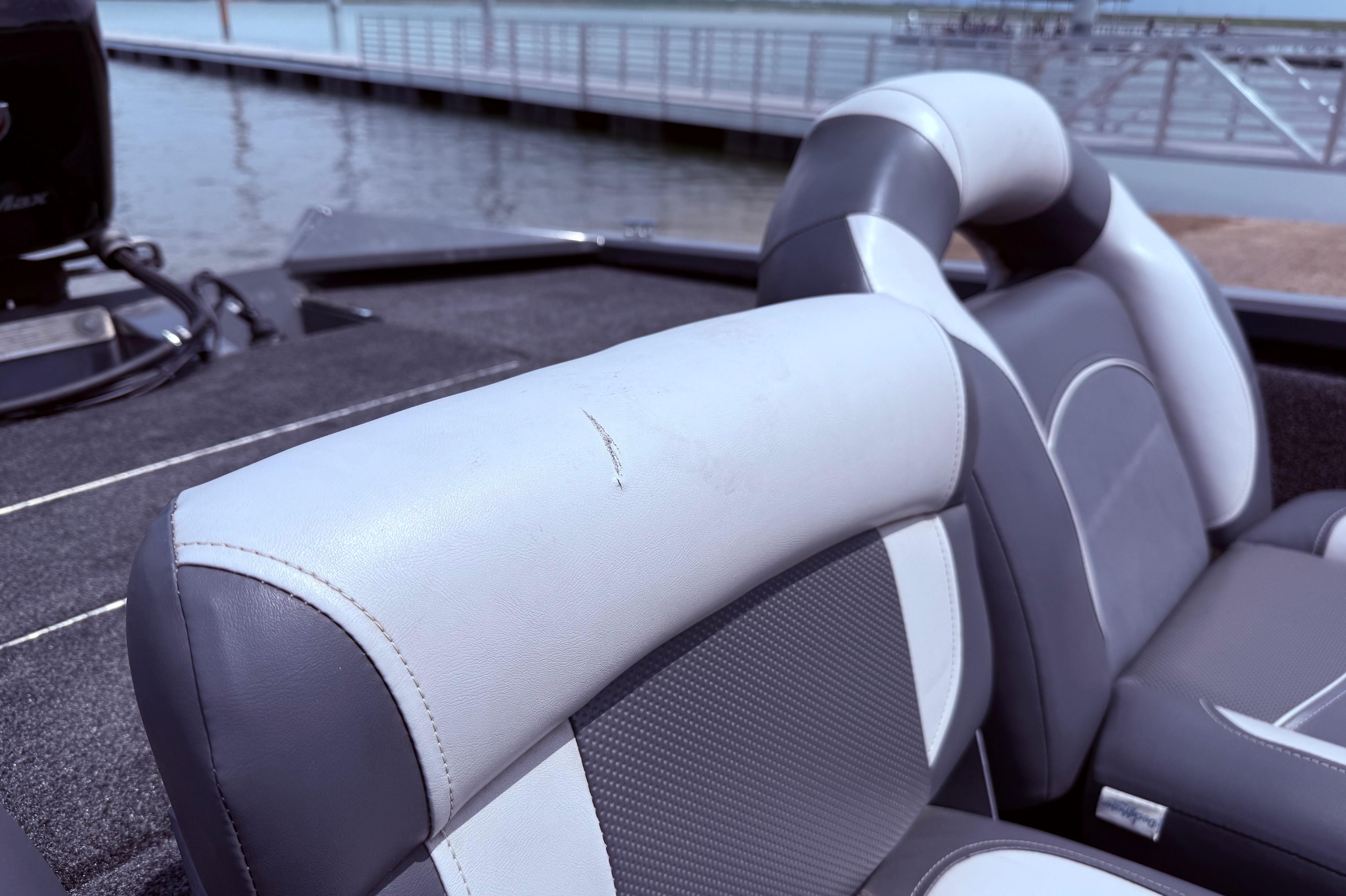 2015 Tracker Pro Team 190 TX boat seats with minor wear, dock in background.