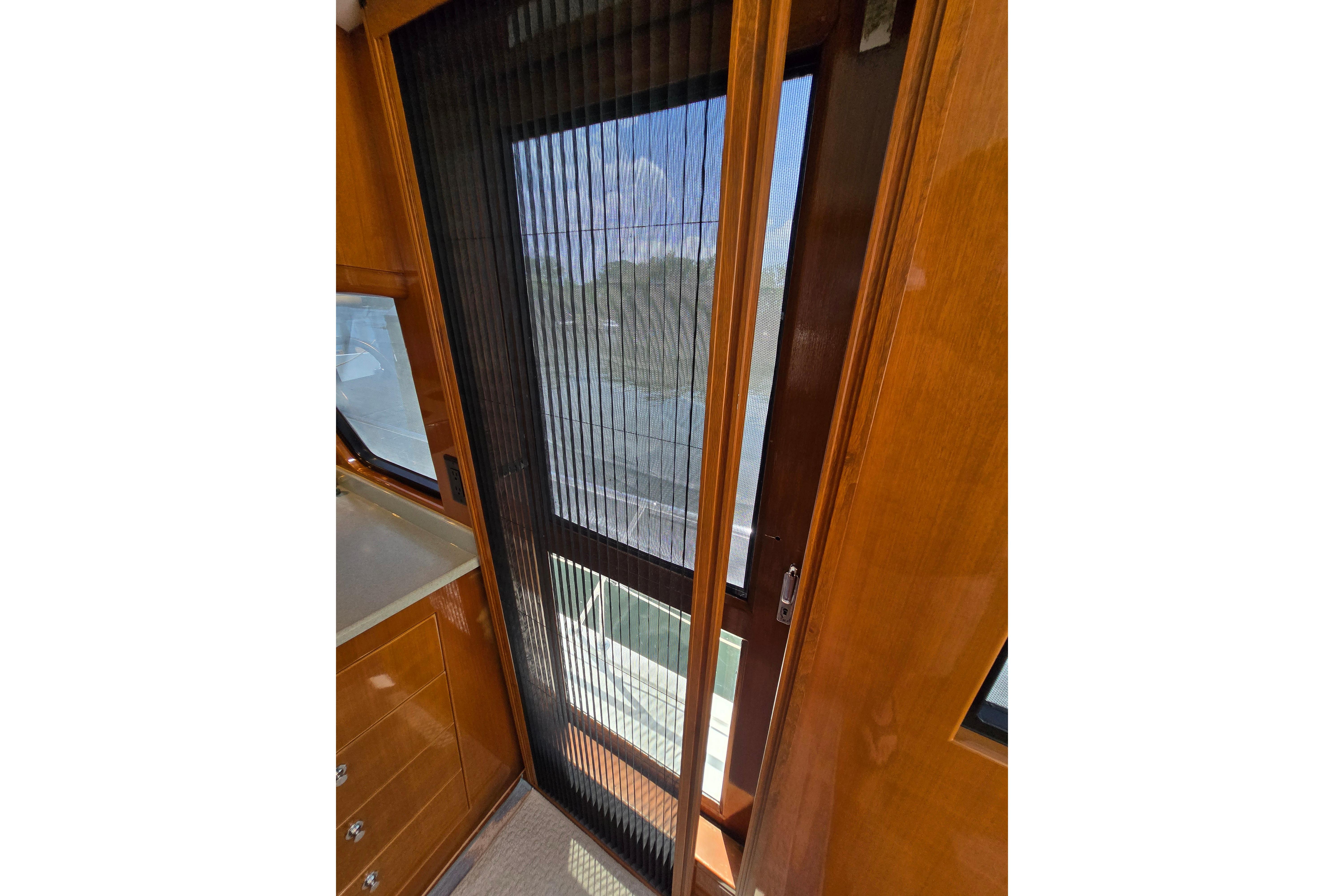 Interior view of 2004 Grand Harbour 58 yacht with wooden cabinetry and sliding door.