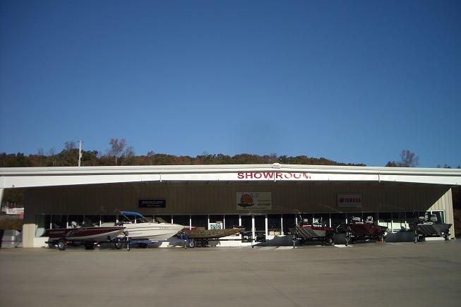 Showroom displaying Sylvan Mirage 820 CLZ DH 2027 boats under a clear blue sky.