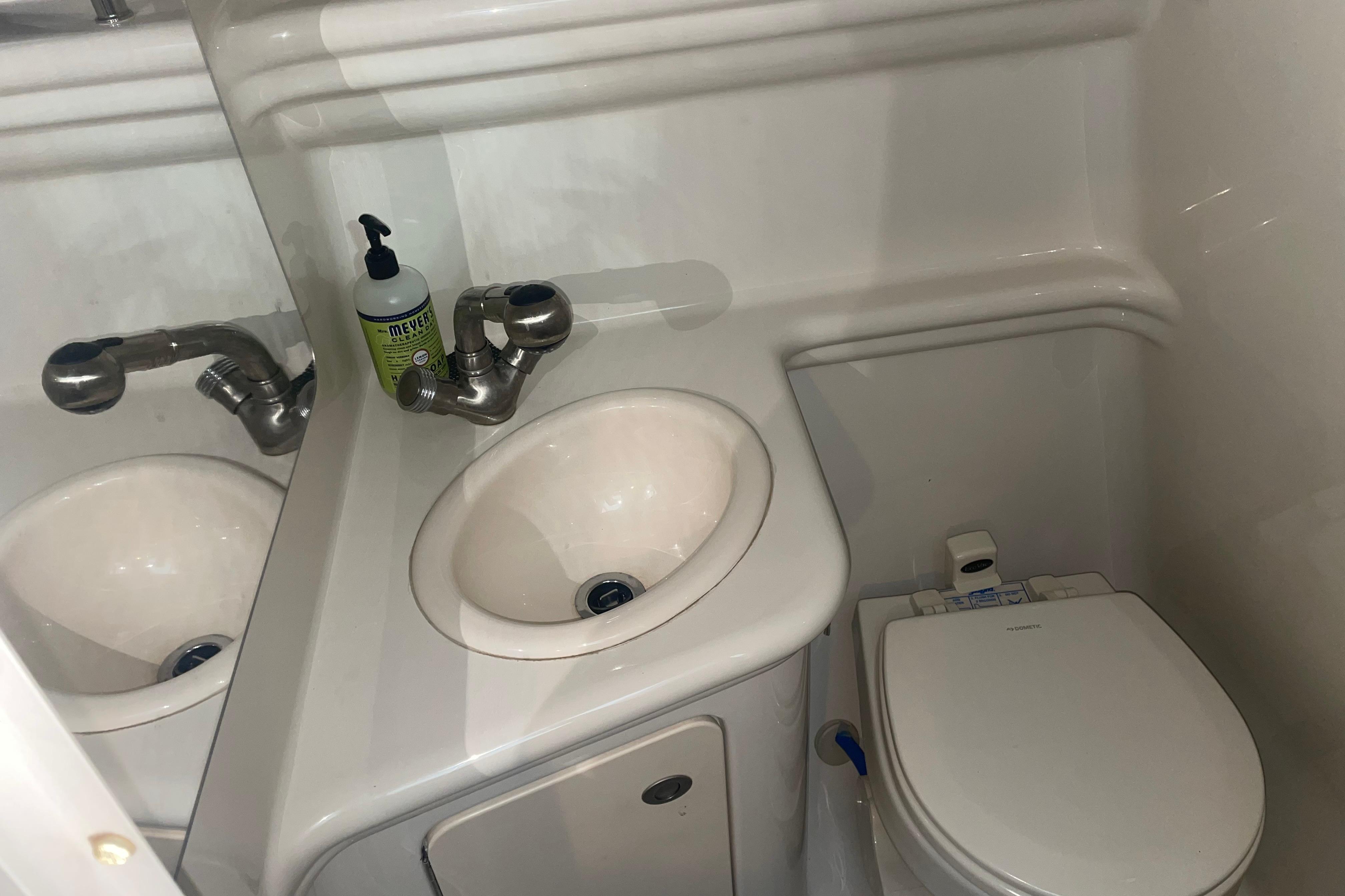 Compact bathroom in 2006 Sea Ray Sundancer 260 boat with sink and toilet.