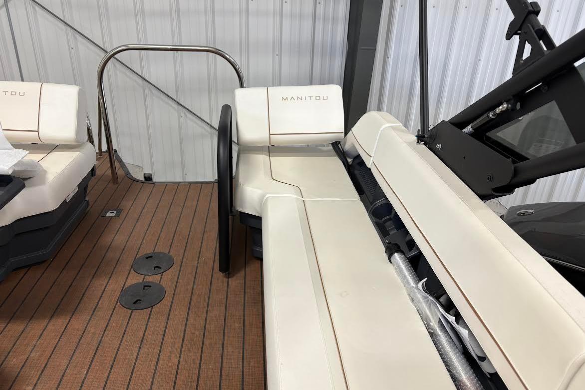 2023 Manitou EXPLORE 26 SHP 575 boat interior with beige seating and wooden flooring.