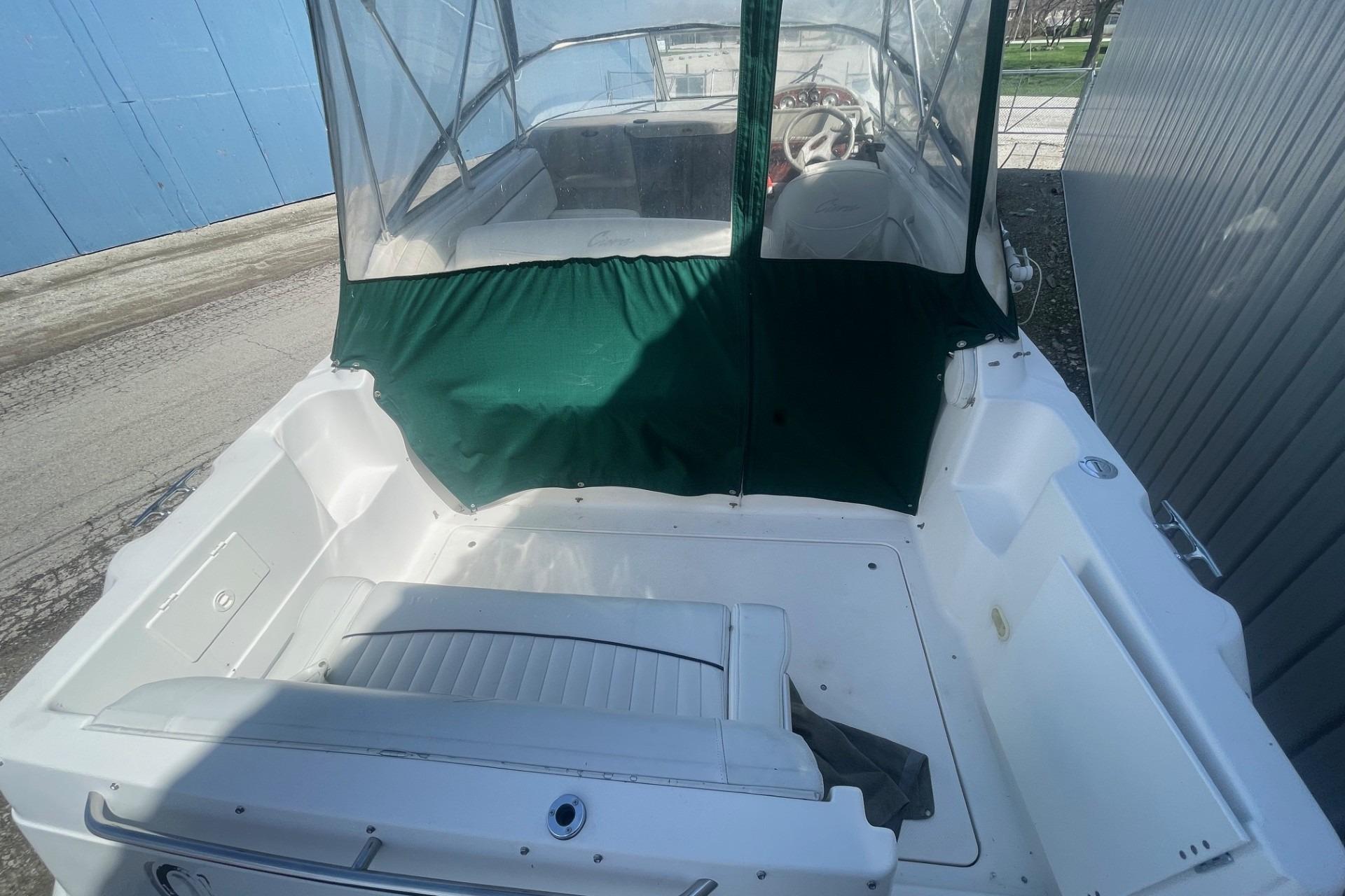 1997 Bayliner 2655 Ciera boat with green canopy and white seating.