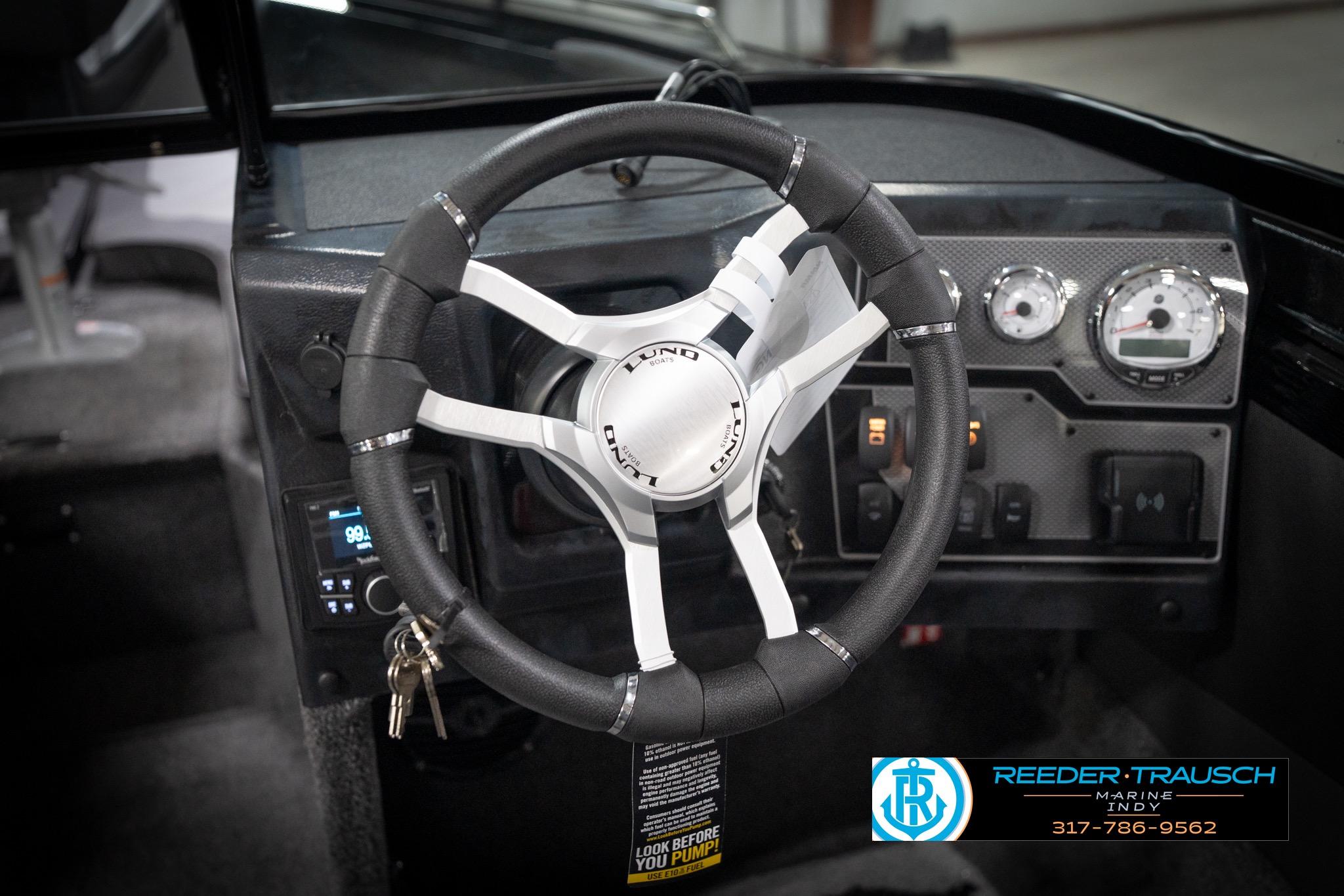 Steering wheel and dashboard of 2026 Lund 2275 Baron boat, featuring modern controls.