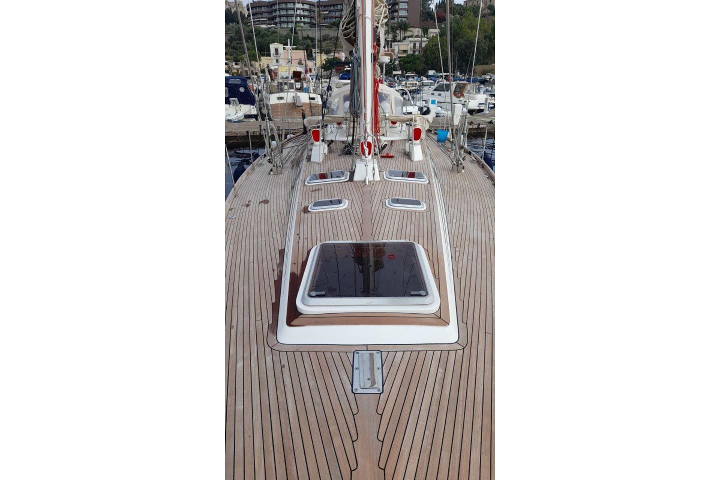 1986 Nautor Swan 61 yacht deck with sleek wooden finish and multiple hatches.
