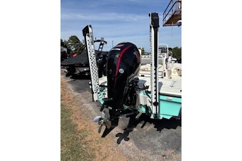 2025 Mako 18 LTS boat with outboard motor and power poles, parked on a sunny day.
