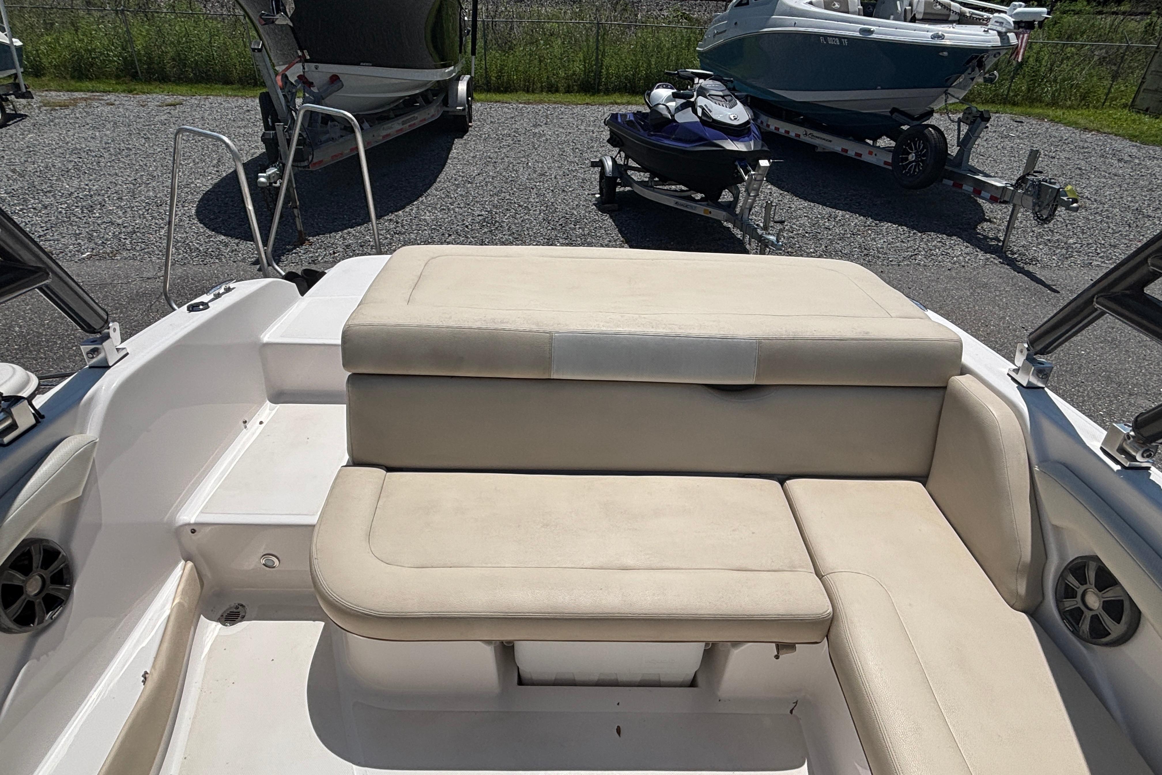 2018 Regal 1900 ES Bowrider interior with beige seating, parked on gravel.