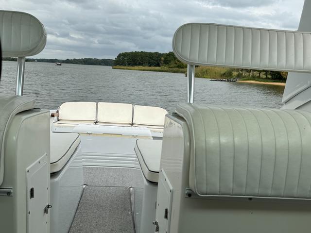 1968 Bertram 31 Bahia Mar boat interior with white seating, overlooking a serene lake.