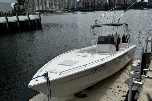 2001 Concept 30 PF Sport boat docked by waterfront buildings.
