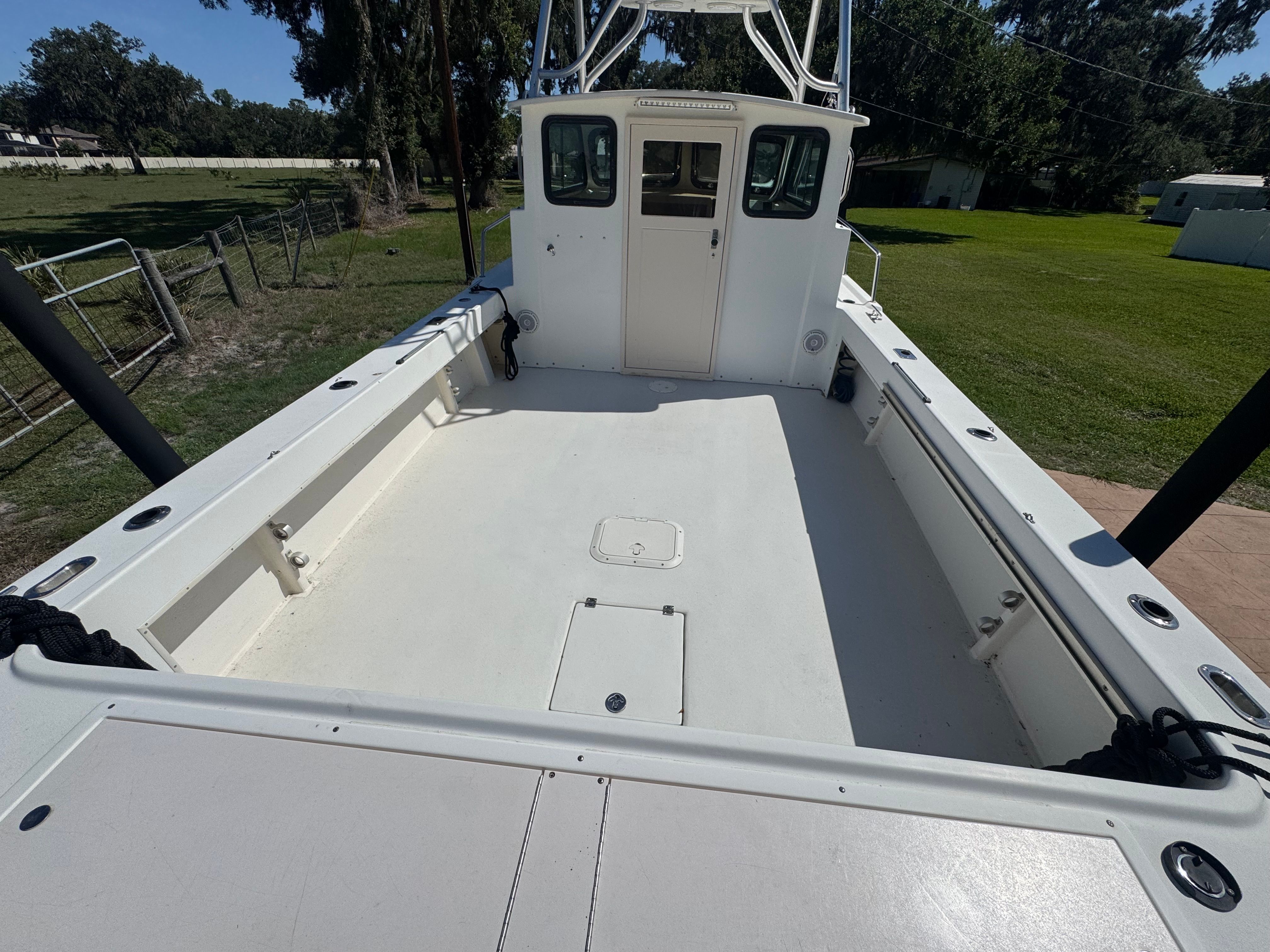 1997 Parker 2520 boat with spacious deck in rural setting.