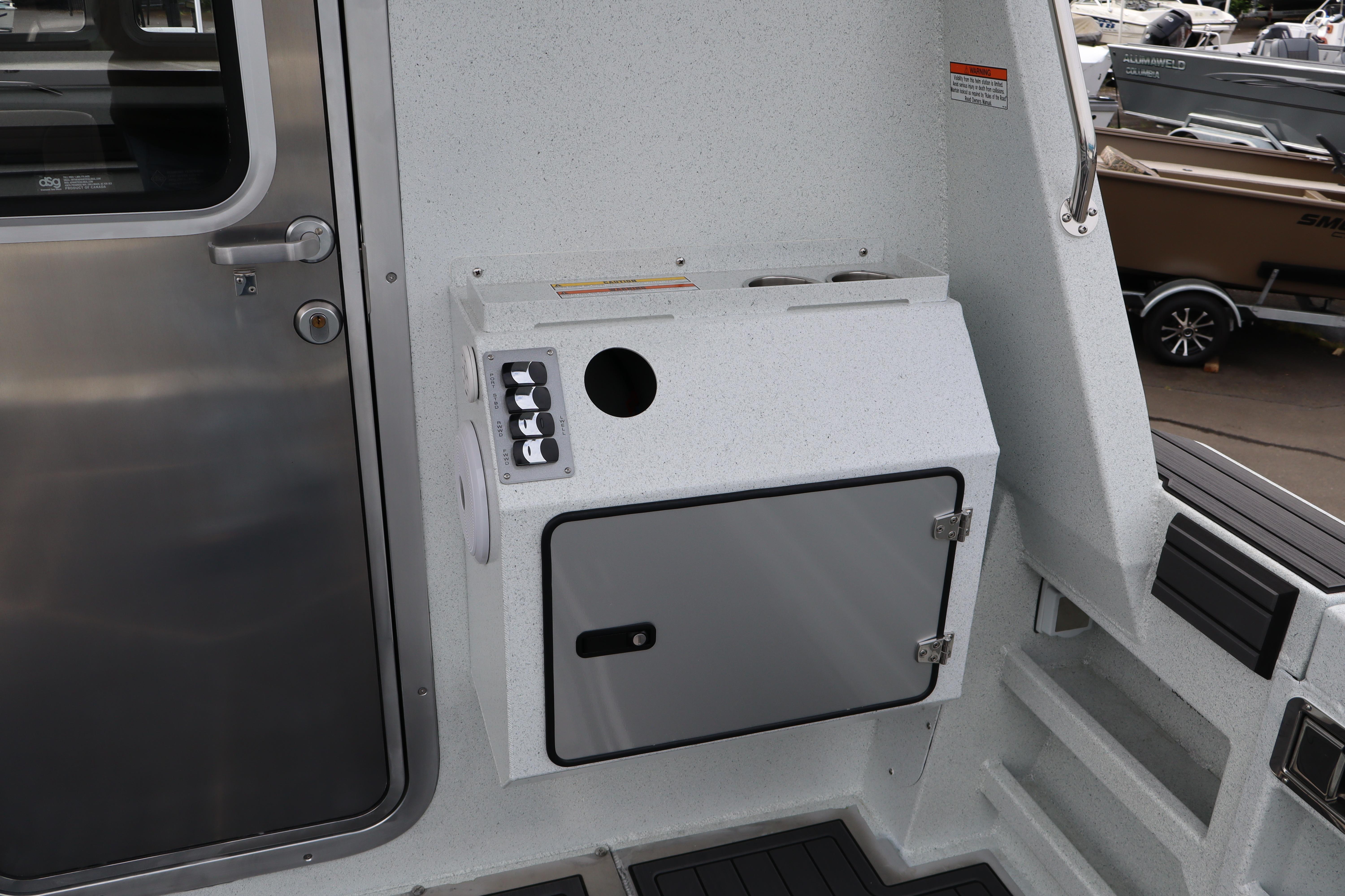 Interior view of 2026 KingFisher 3025 XRS boat, featuring a control panel and storage compartment.