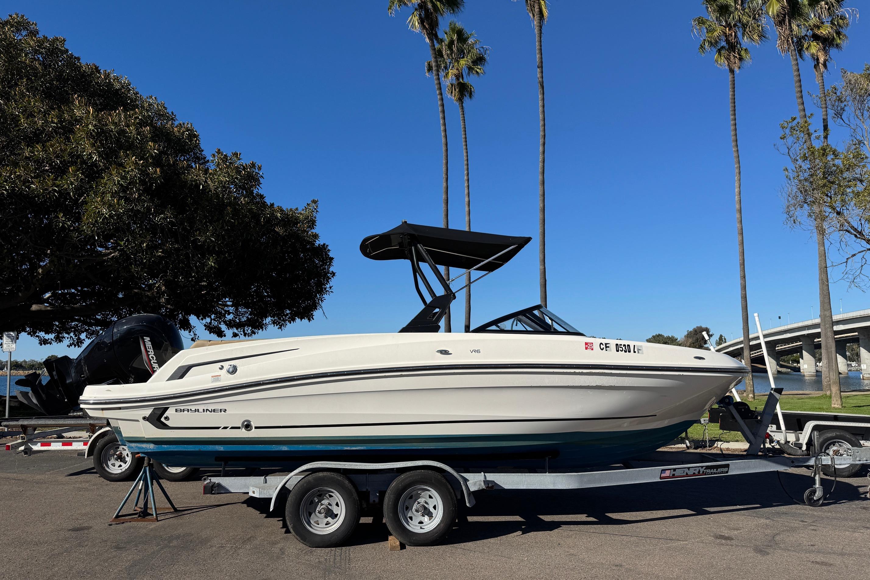 2022 Bayliner VR6 Bowrider OB on trailer, parked near palm trees and water.