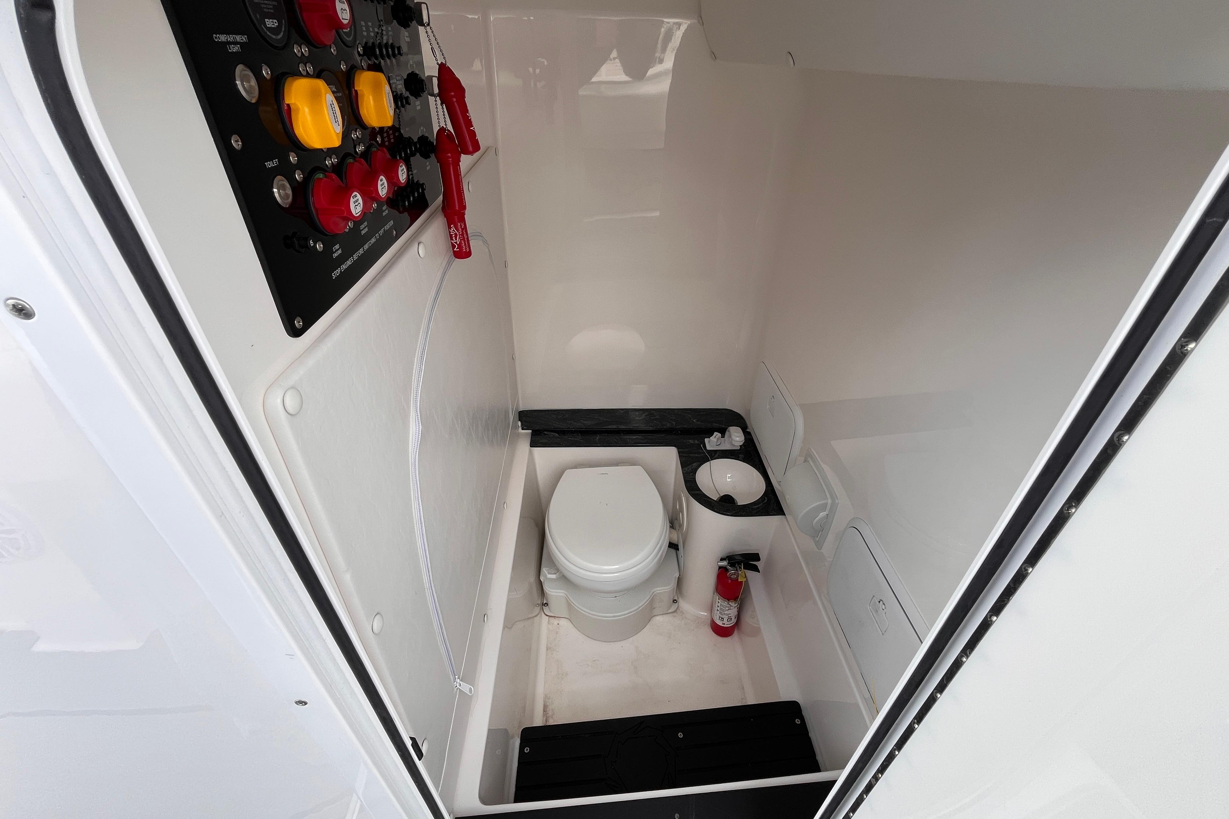 Interior of 2026 Fountain 38 Tournament Edition boat with toilet and control panel.